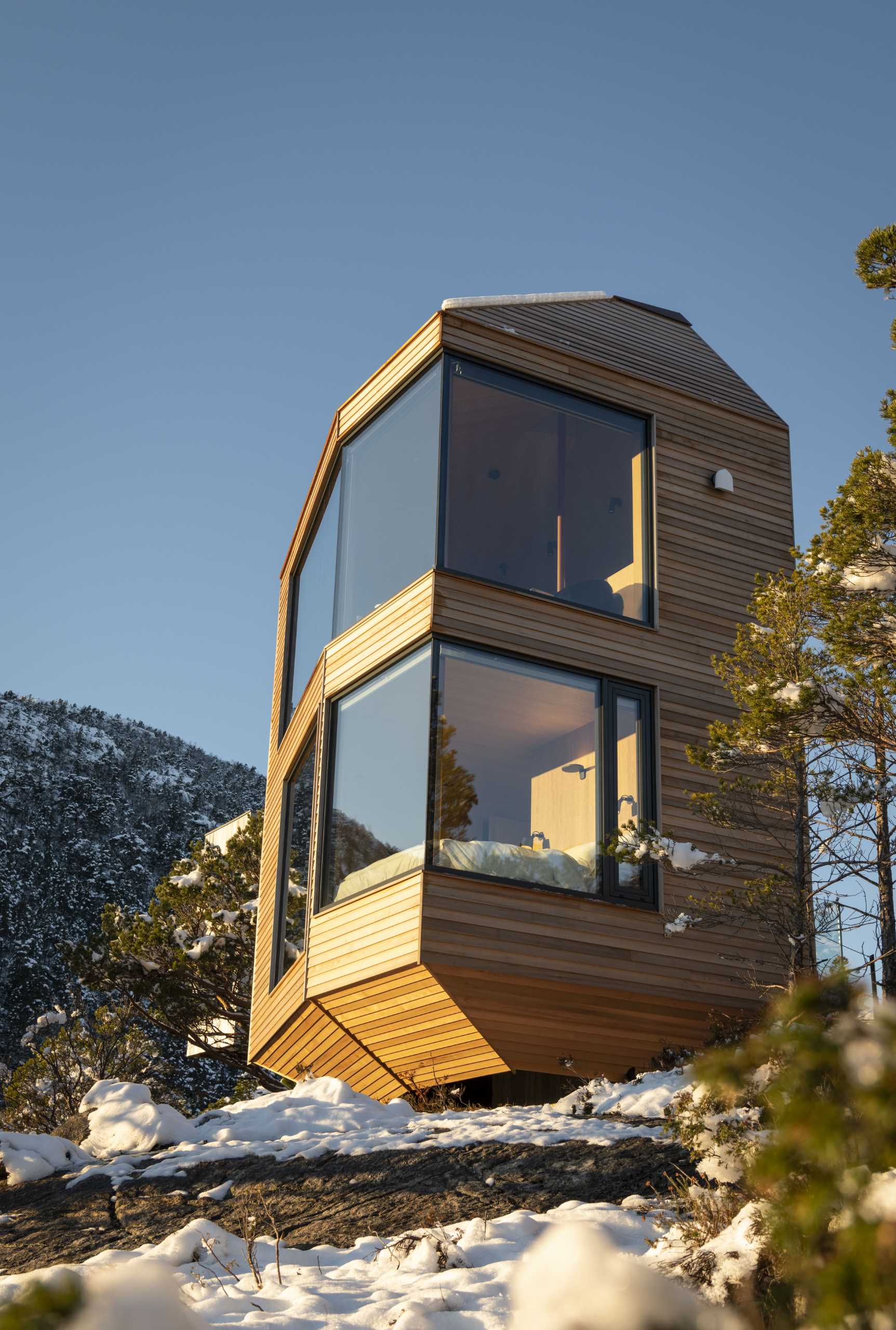 A modern cabin that's built to blend in with the landscape with a minimal footprint on the surrounding nature.
