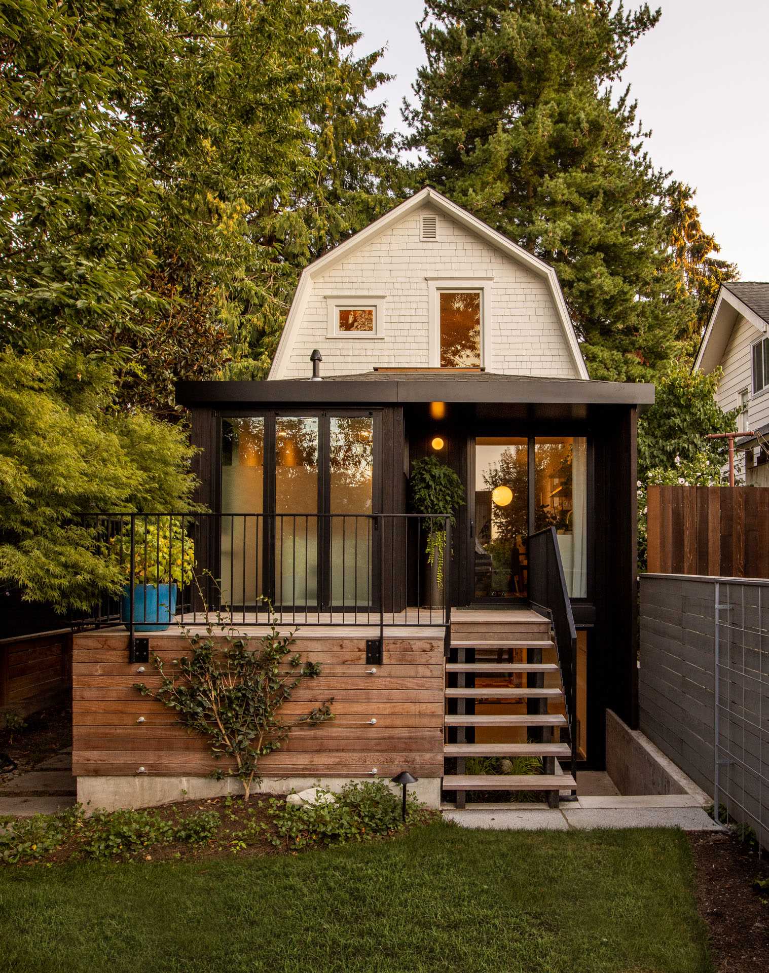 The updated rear of this modern home showcases the new extension, as well as a deck with stairs that lead down to the yard.