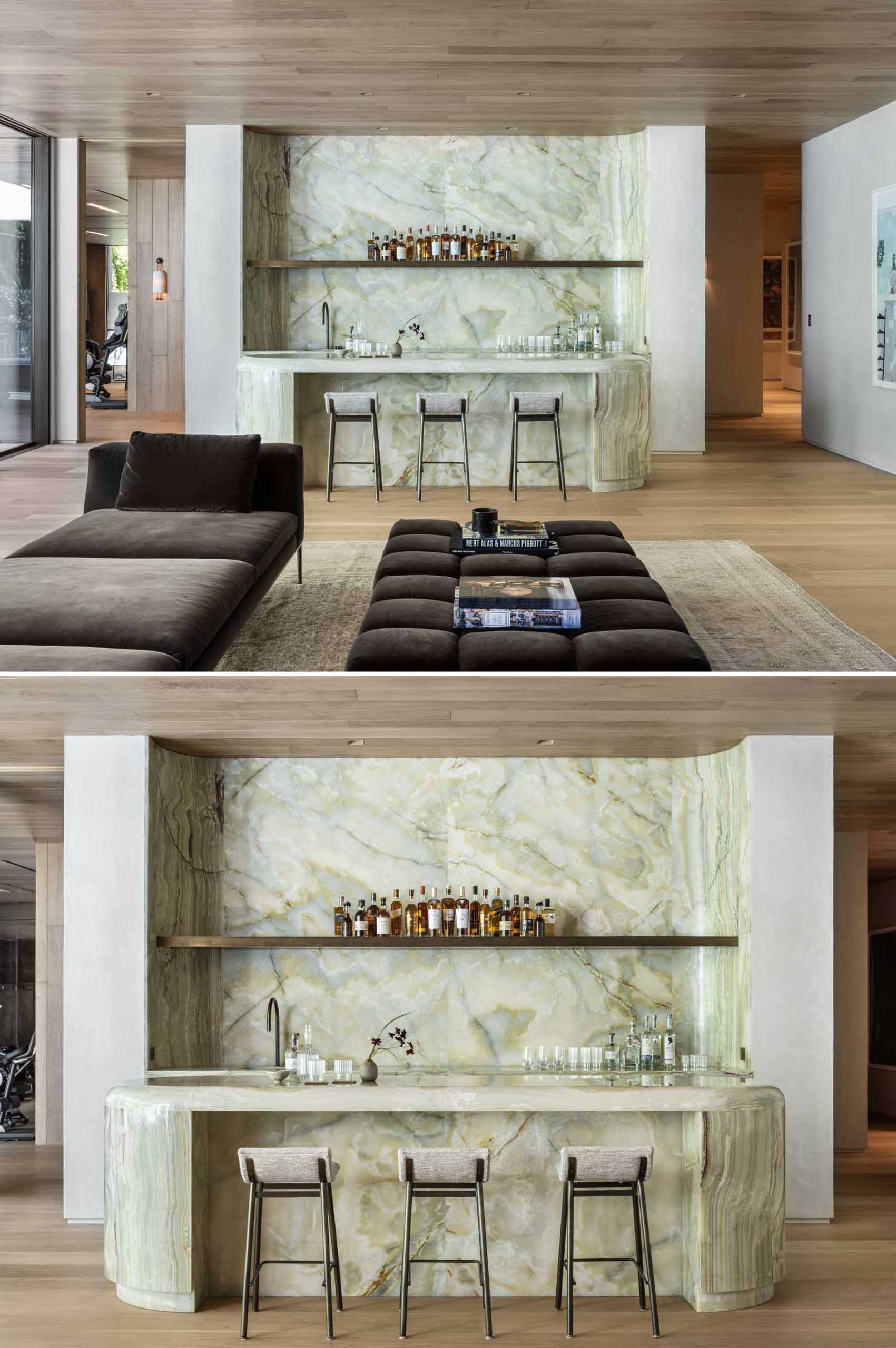 A custom bar lined with green stone draws attention and offers another place to relax in the home.