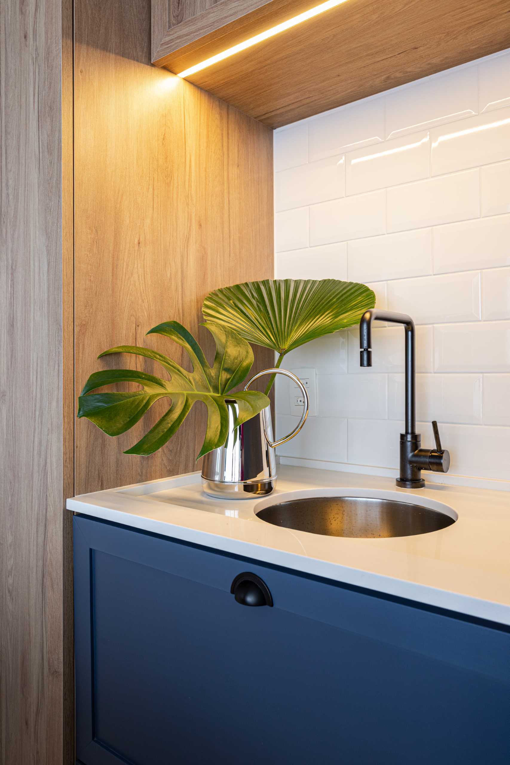 Under-cabinet lighting aids in illuminating the countertop and sink in this small kitchen.