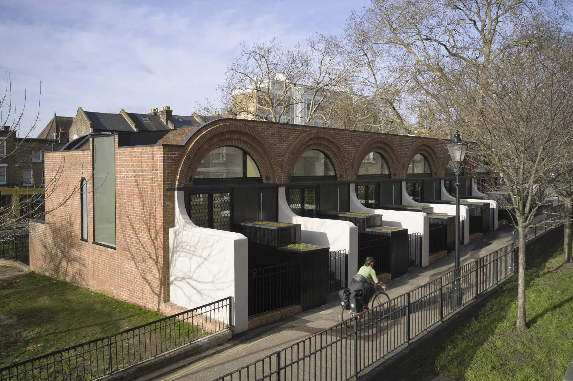 Arches appear at the entry of these townhouses in the form of metal shutters on the windows adjacent to the front doors.