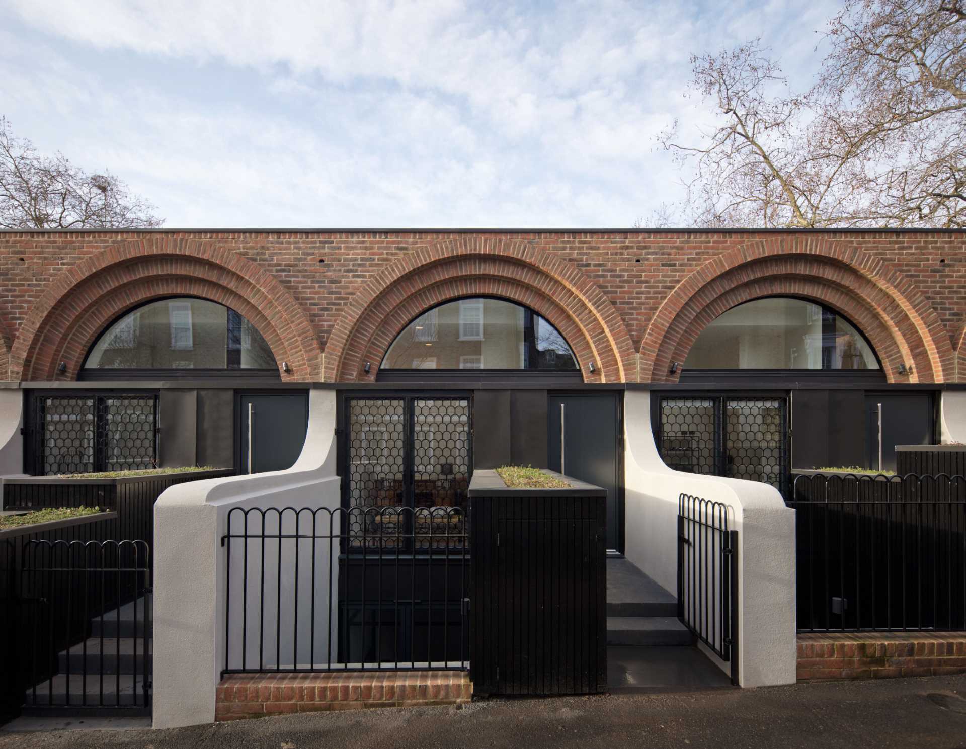 Arches appear at the entry of these townhouses in the form of metal shutters on the windows adjacent to the front doors.