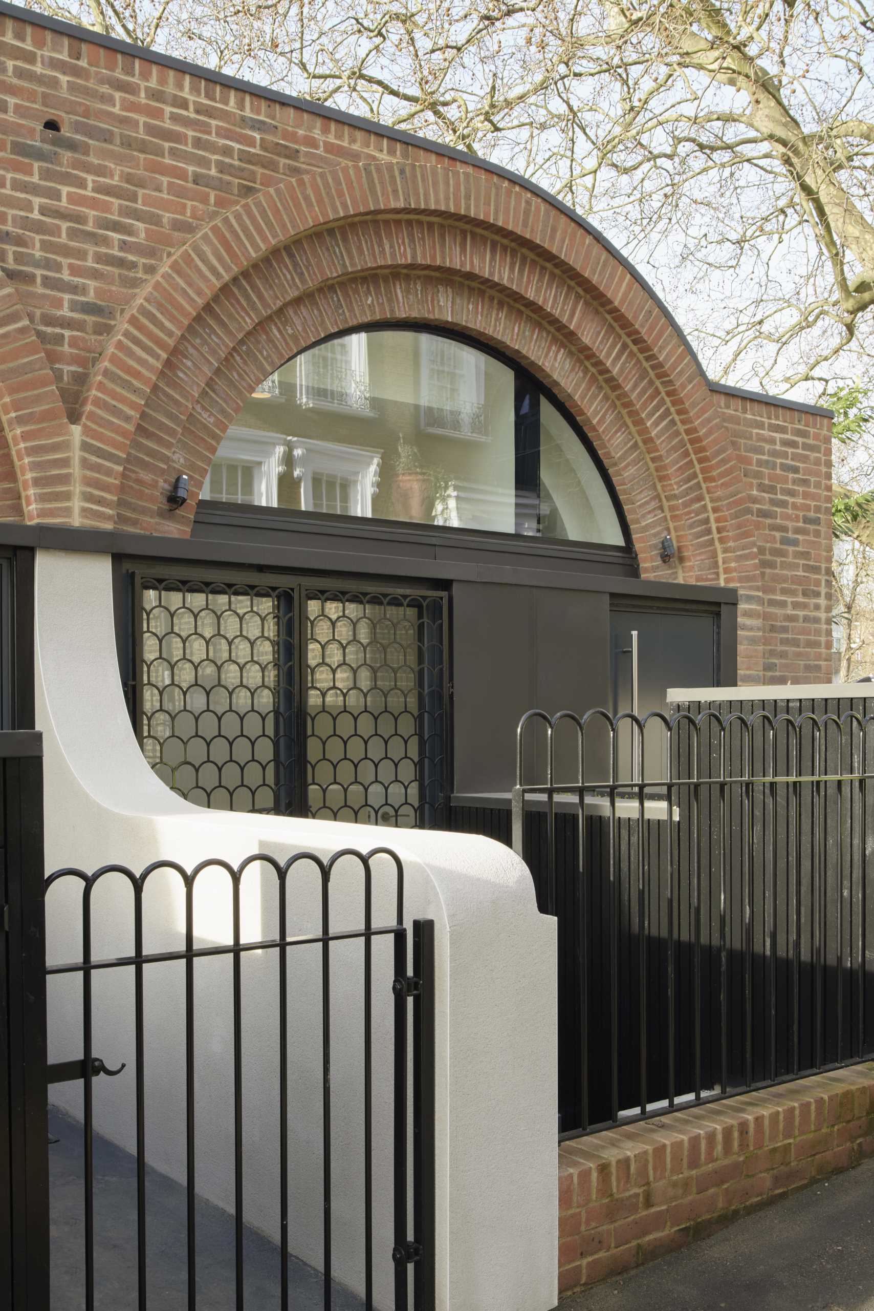 Arches appear at the entry of these townhouses in the form of metal shutters on the windows adjacent to the front doors.