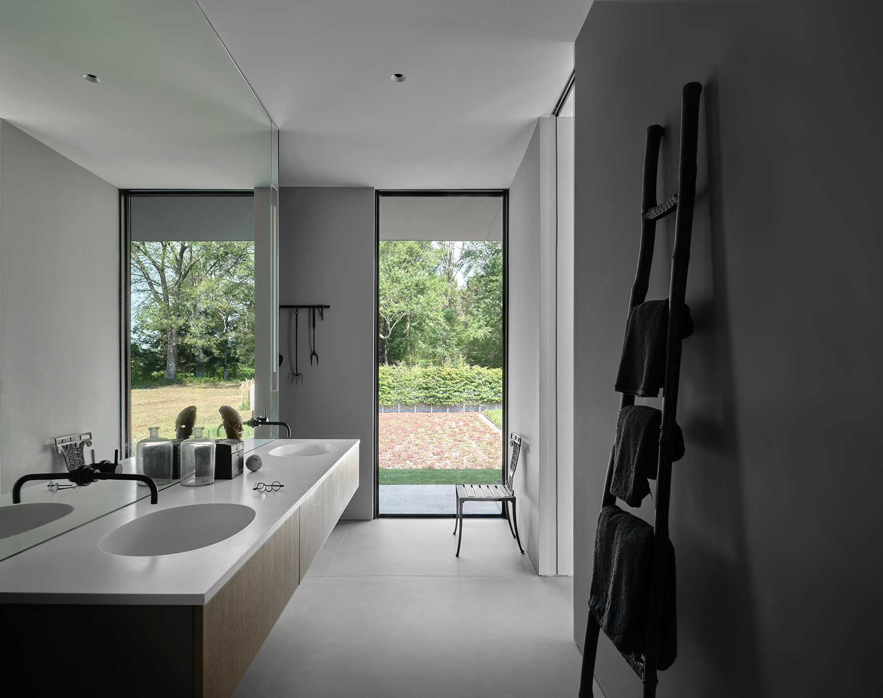 This modern primary bathroom has a floating double vanity, while a vertical window adds natural light.