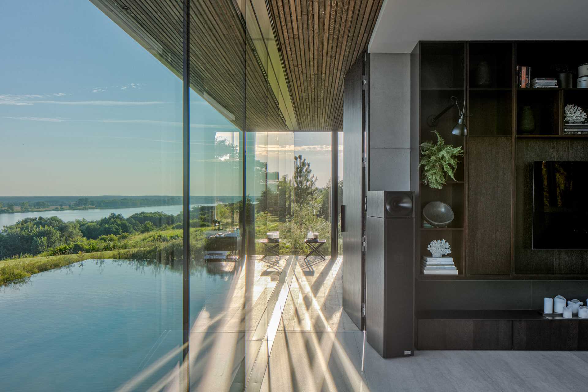 A modern home that has floor-to-ceiling windows that travel from the living room through to the primary bedroom.