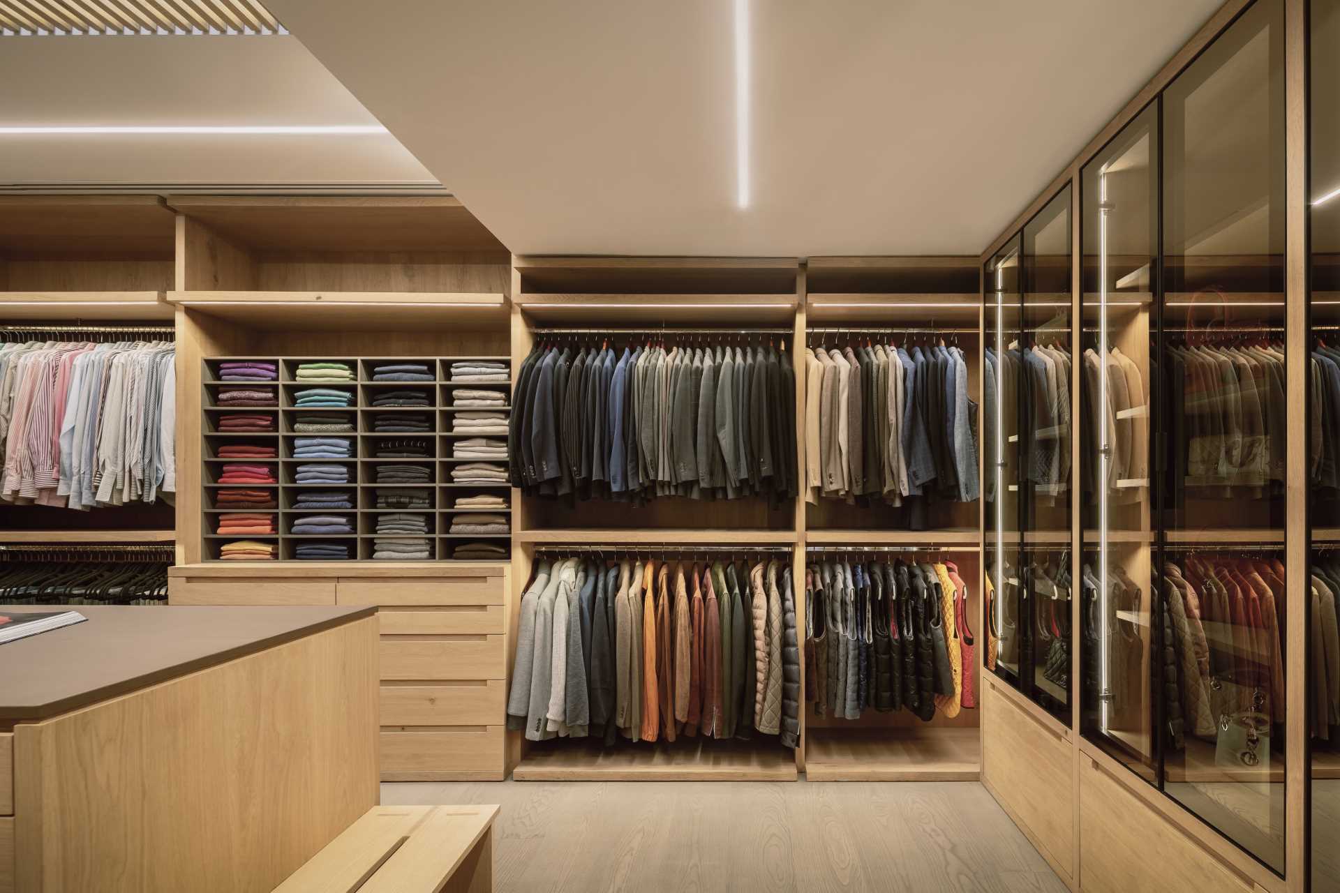A large walk-in closet with plenty of storage for clothes and accessories. Hidden lighting is also included above each of the closet rods.