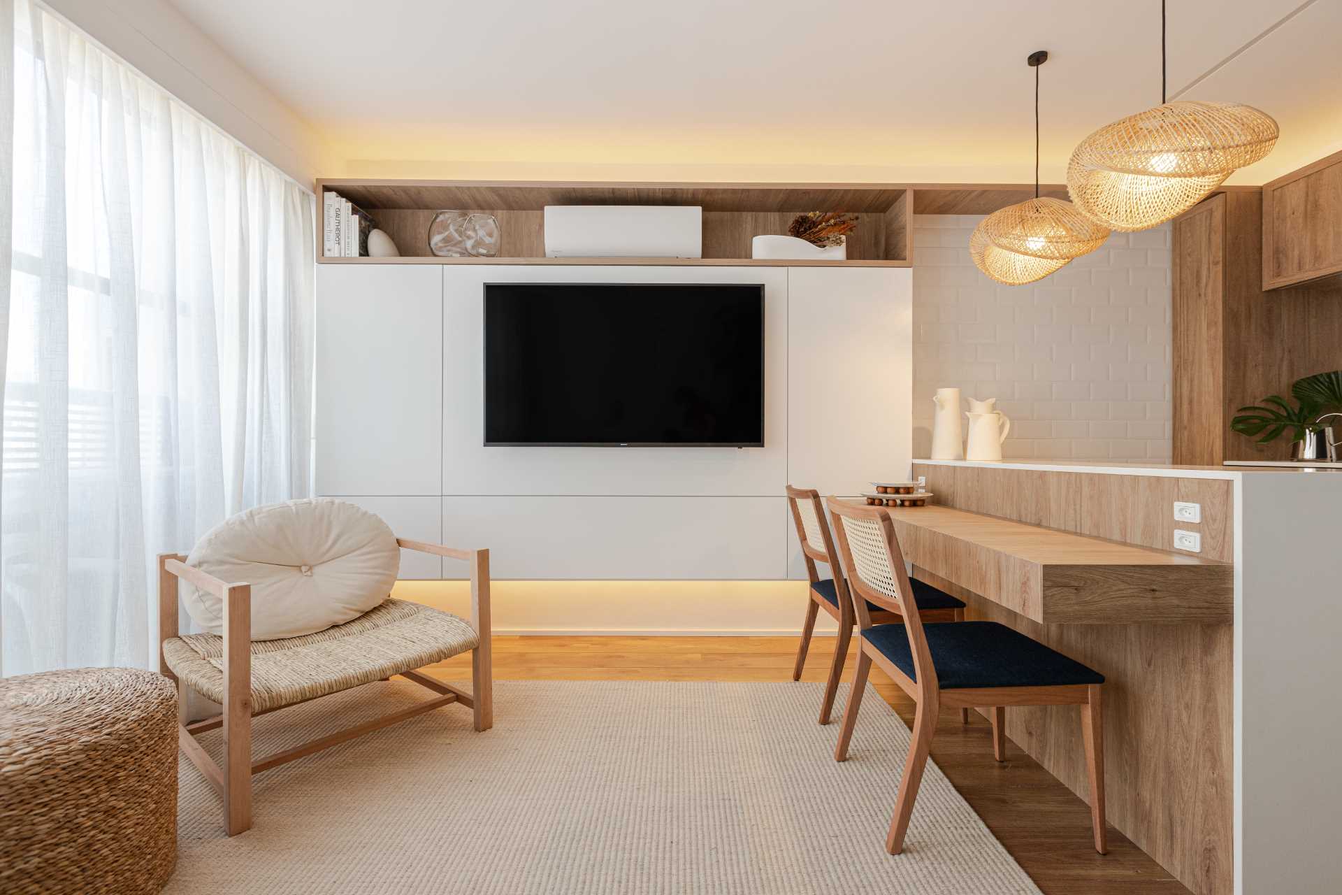 A wall dedicated to the TV and shelving is located on the wall opposite the couch. Hidden lighting adds a soft glow to the space.