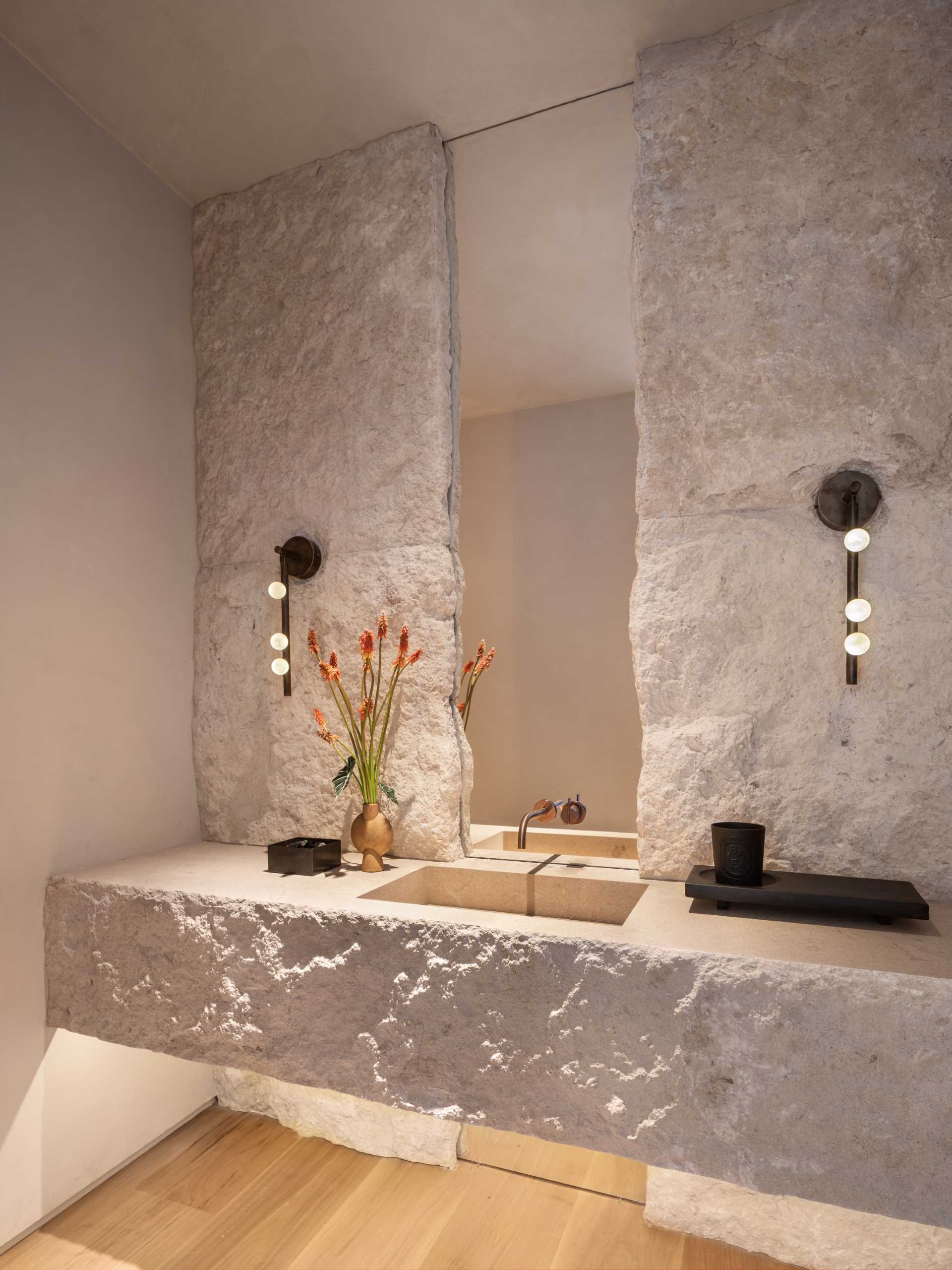 A modern bathroom with stone accent wall that matches the vanity.