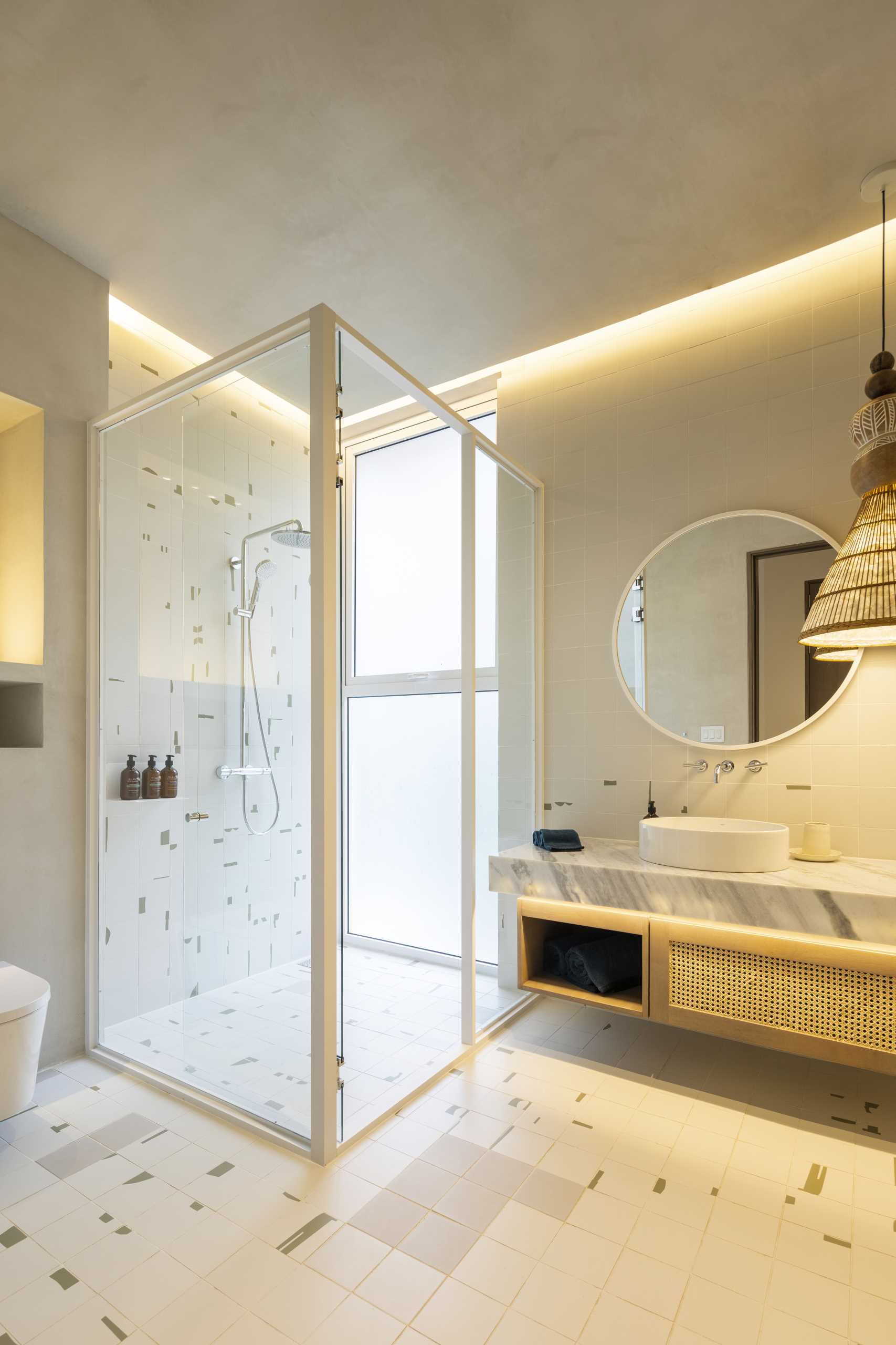 A modern bathroom with hidden lighting, a floating vanity, and a walk-in shower.