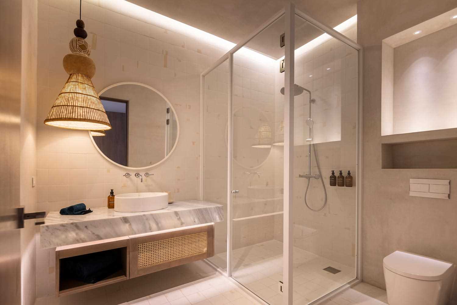 A modern bathroom with hidden lighting, a floating vanity, and a walk-in shower.