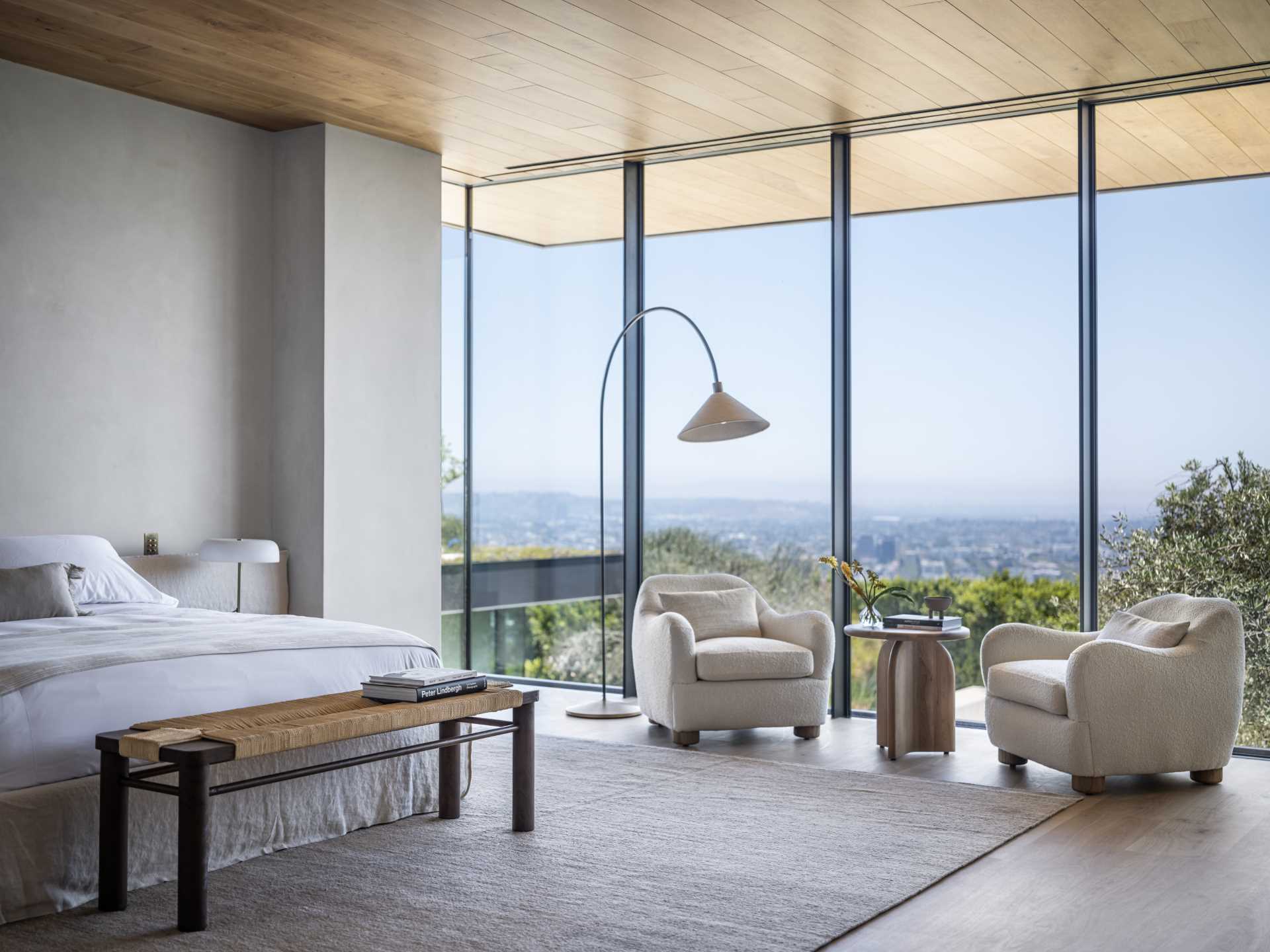 A modern bedroom with floor-to-ceiling windows.