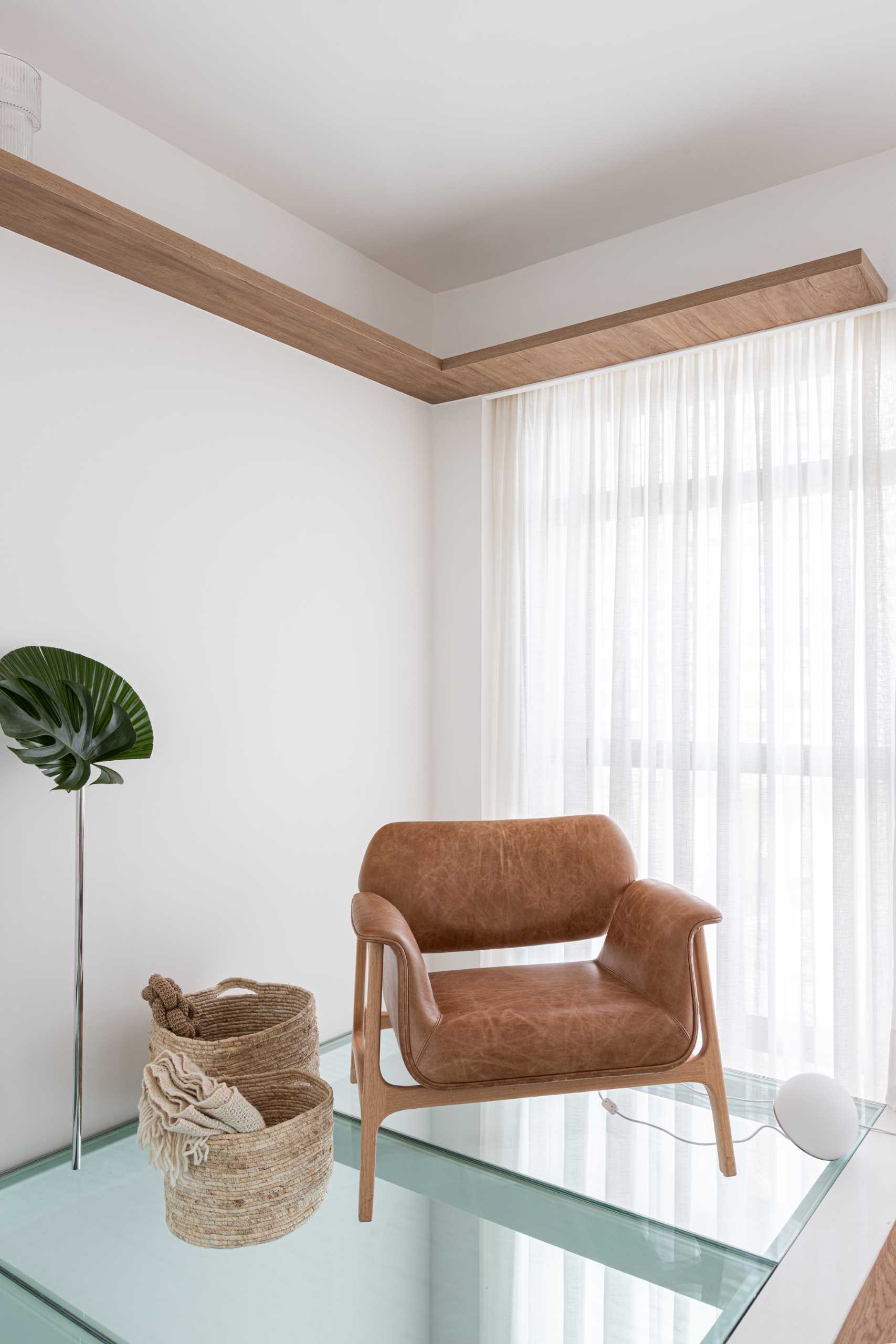 A modern bedroom with a partial glass floor that allows natural light to pass through to the living room below.