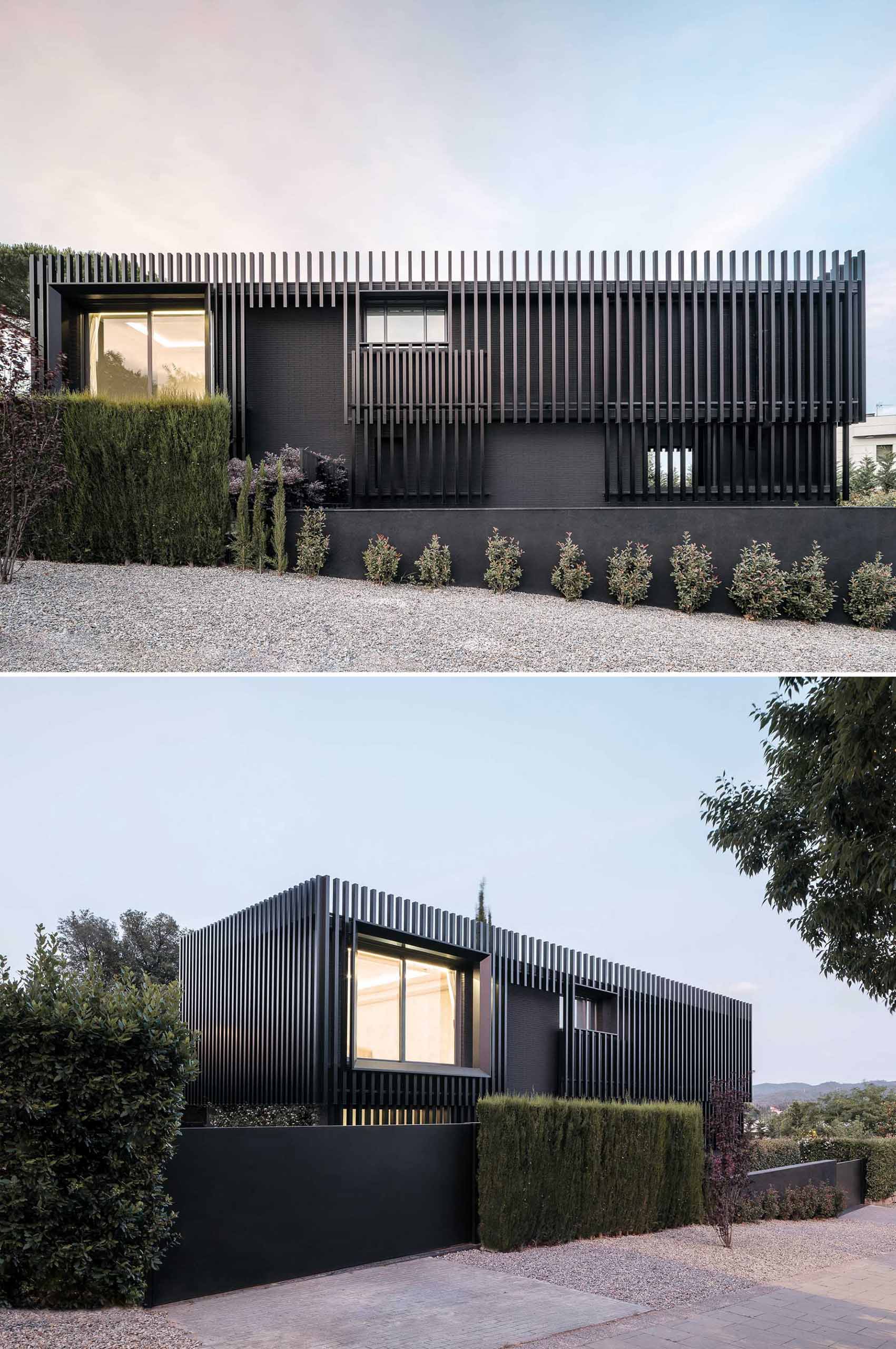 A modern black house has vertical planes that wrap around its exterior, creating a monochromatic appearance.