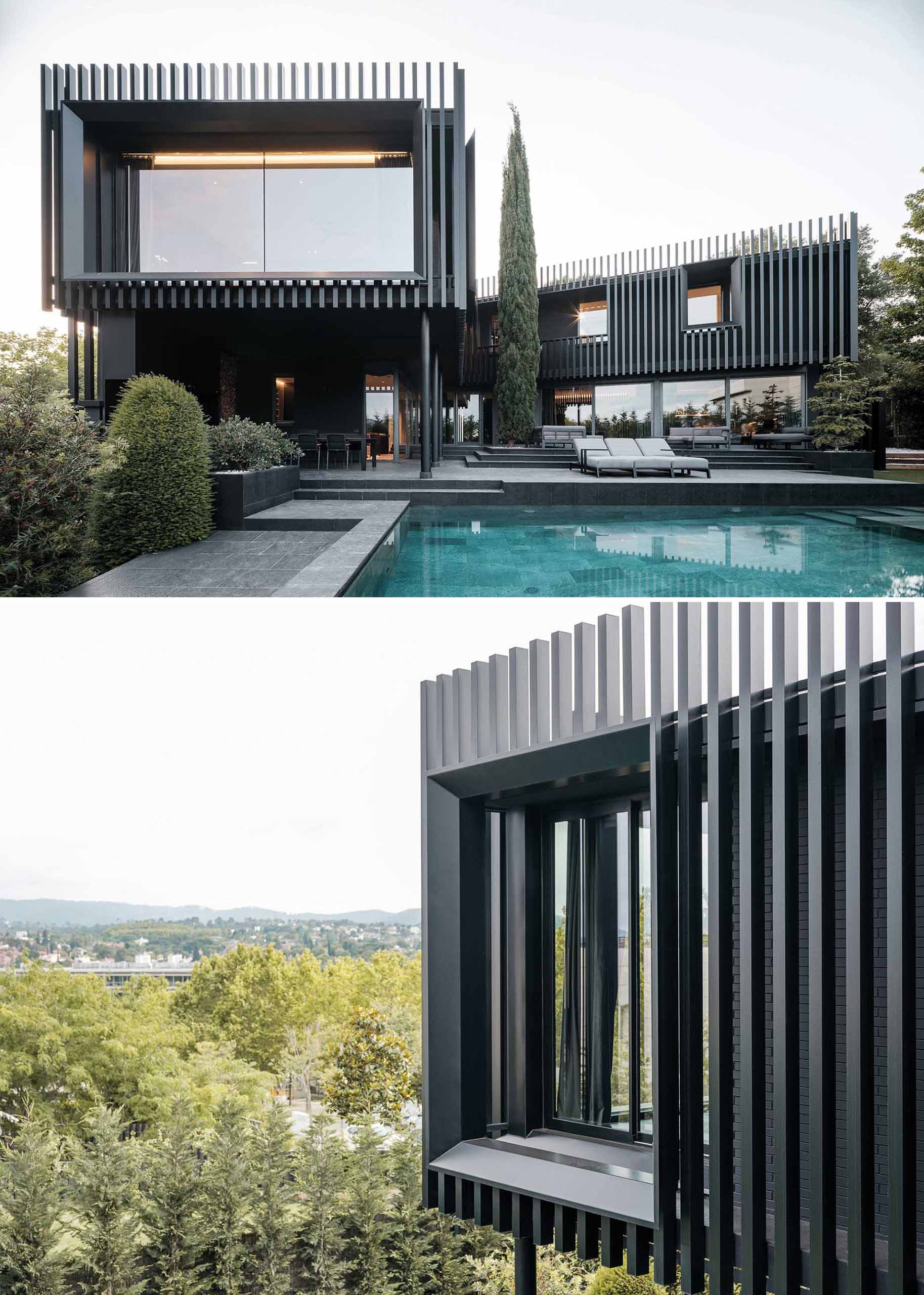 A modern black house has vertical planes that wrap around its exterior, creating a monochromatic appearance.