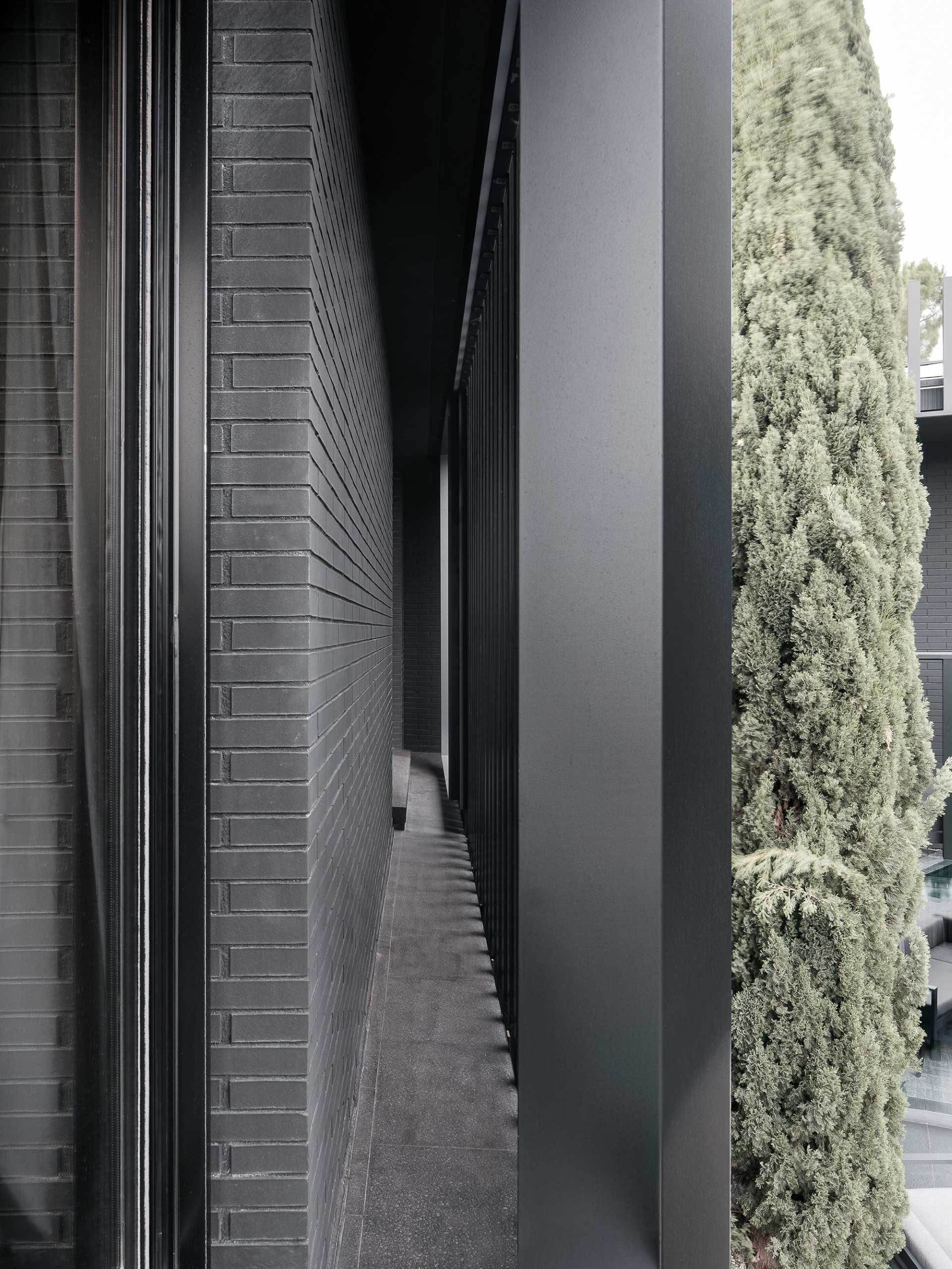 A modern black house has vertical planes that wrap around its exterior, creating a monochromatic appearance.