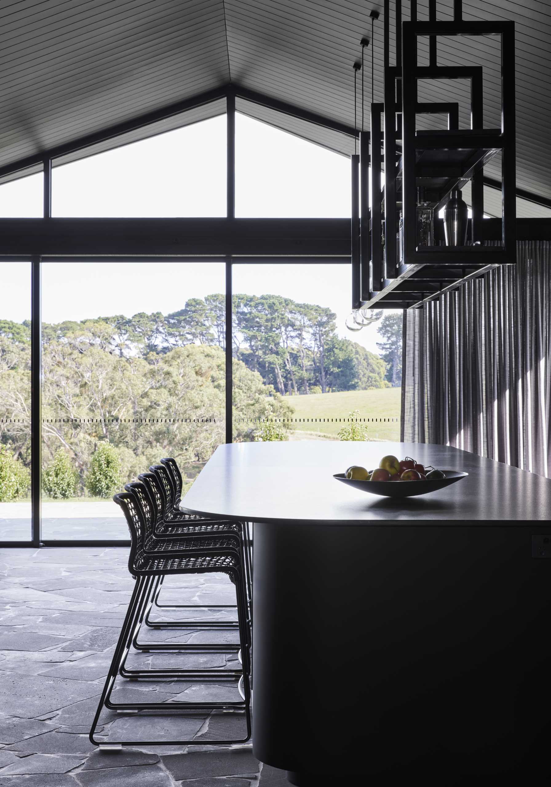 A modern black kitchen that's designed as a full-sized bar with a gentleman's club aesthetic.