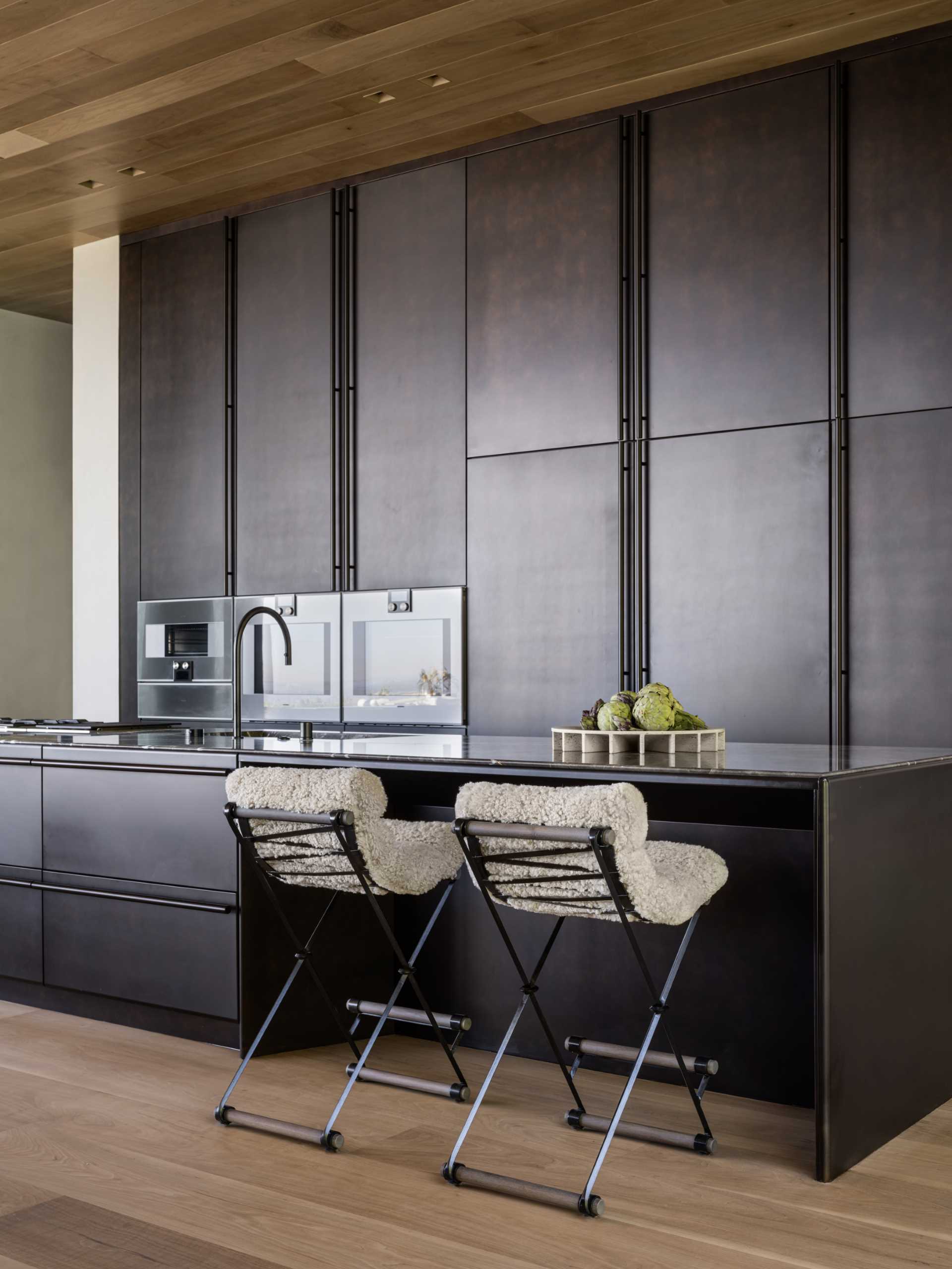 This modern kitchen makes a bold statement, with matte black cabinets and double islands.