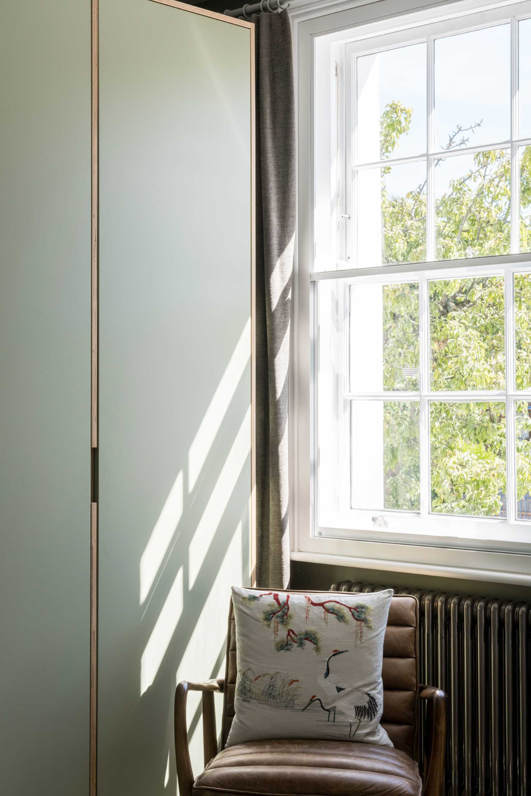 In this modern bedroom, matte green was the chosen color, and is featured on the walls as well as the closets. Wood accents provide a natural contrasting element.