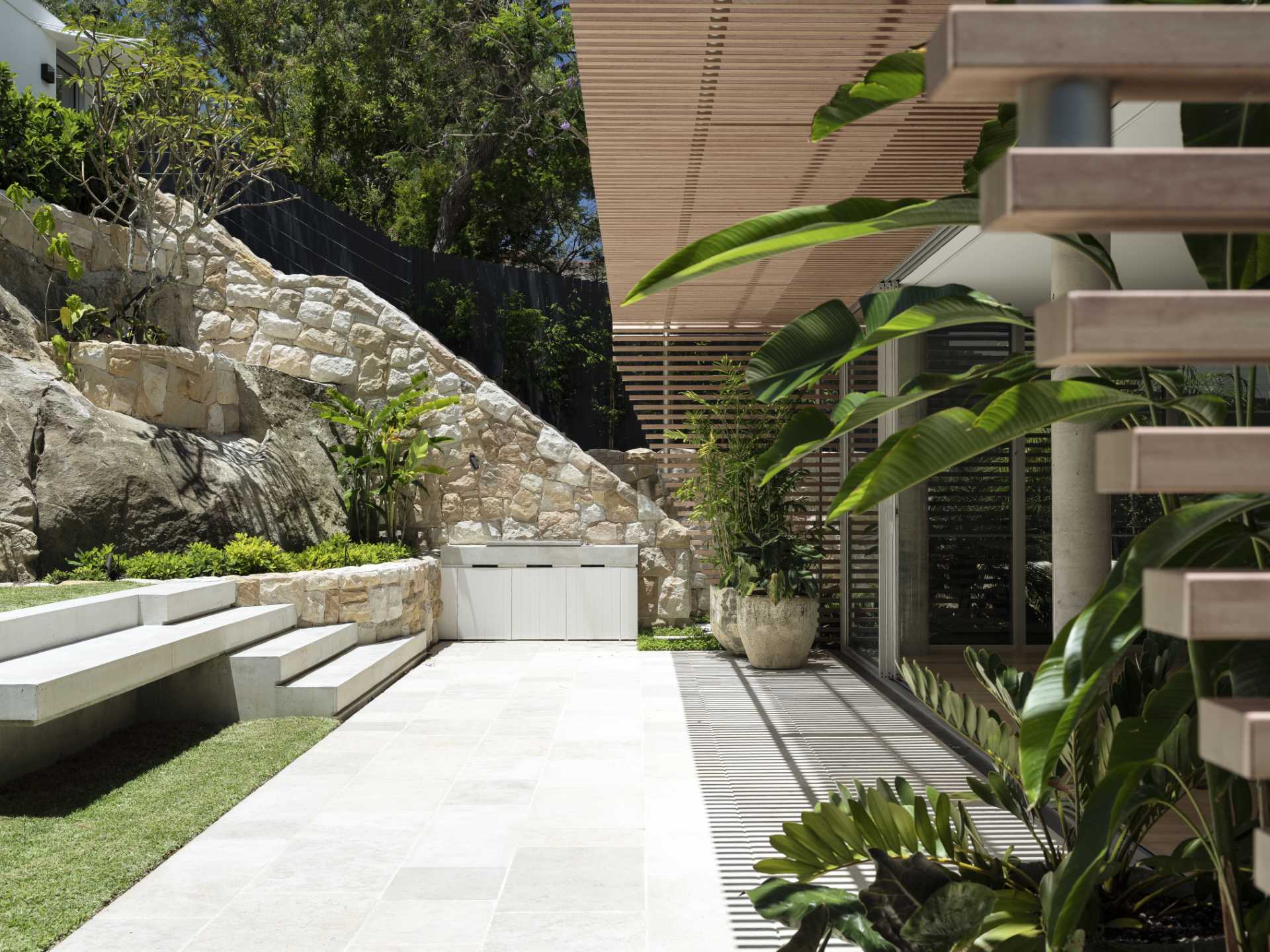 A landscaped garden that features sandstone and a bbq.