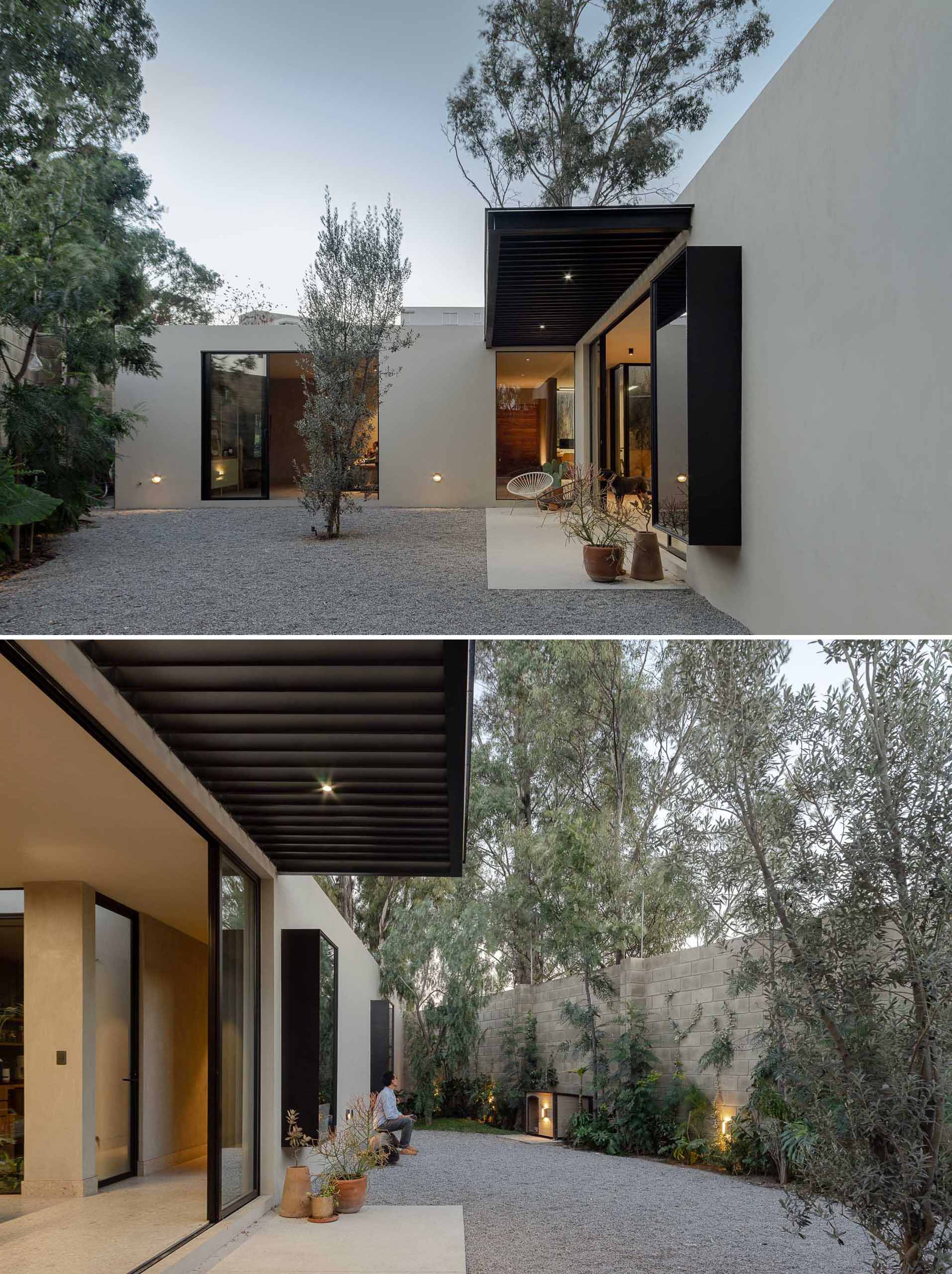 The rear of this modern home has been designed in such a way that the interior spaces open to the low-maintenance gravel patio. Trees and shrubs soften the walls and provide shade. 