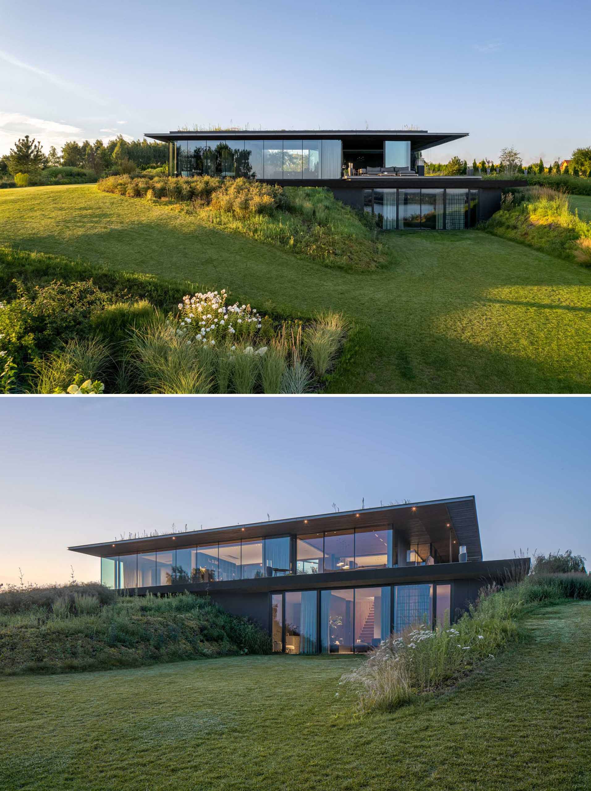 A modern house is nestled into the landscape, with a lower floor having direct access to the yard.