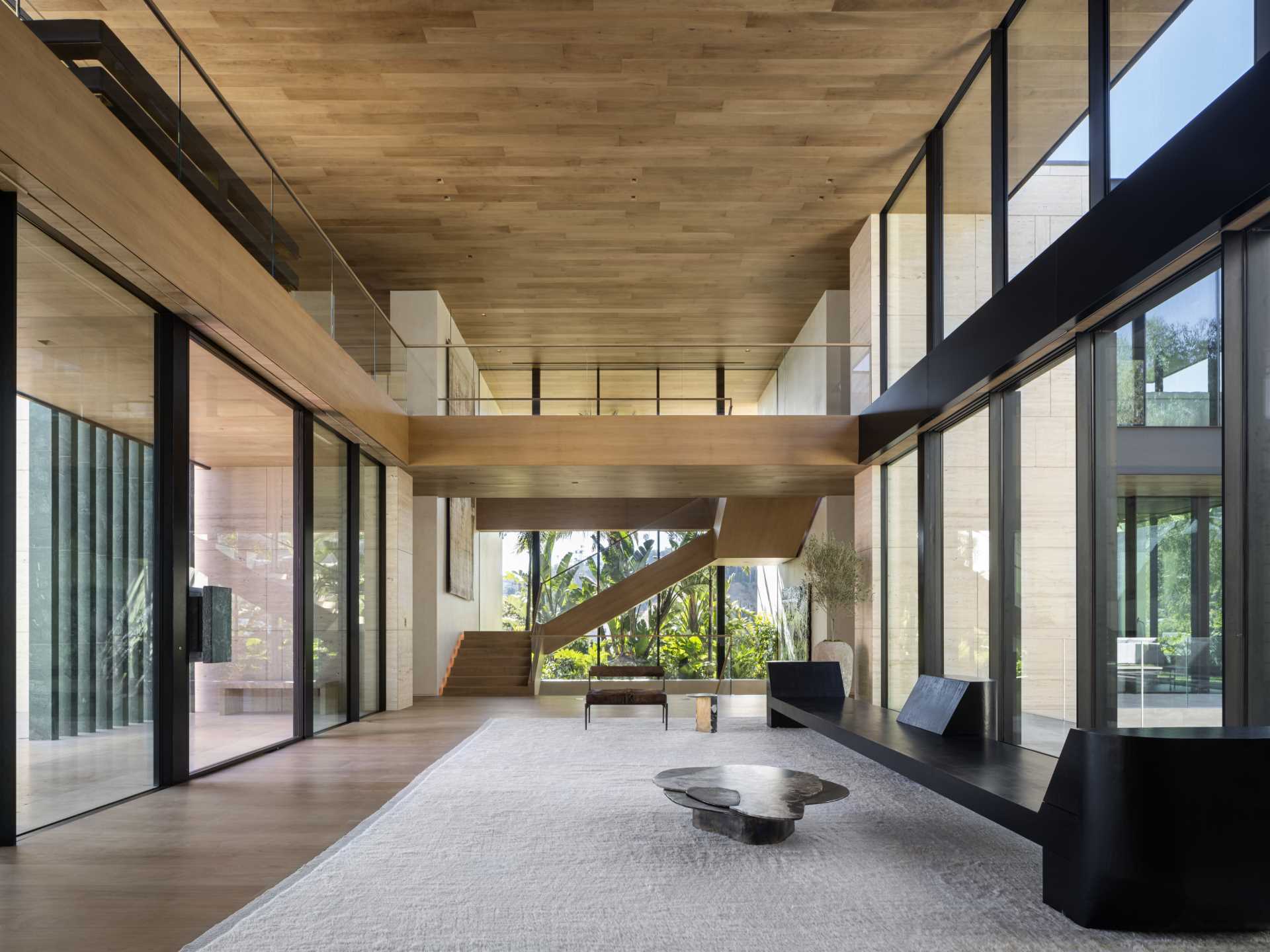 A modern house with a double-height foyer that has a wall of windows.