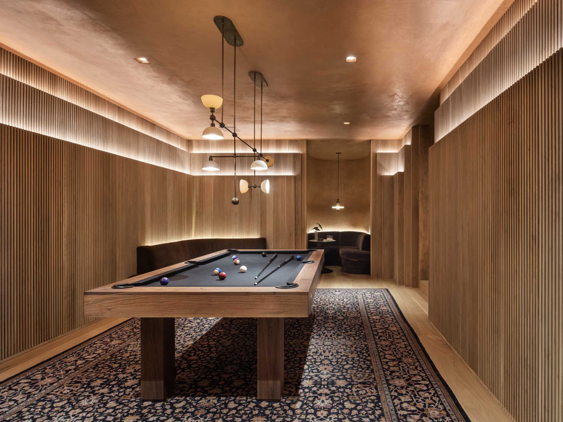 A modern home with a billiards room and seating nook.