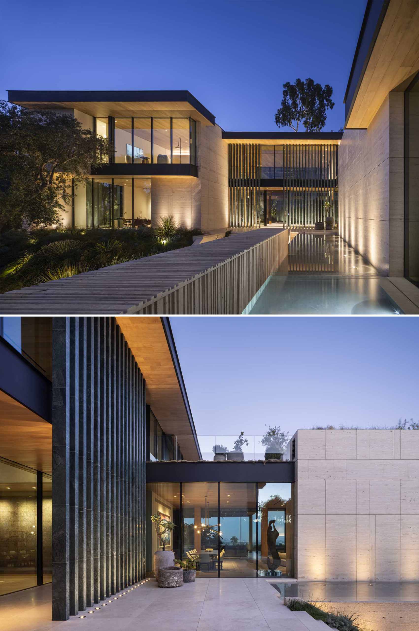 Outdoor lighting highlights the design features and landscaping of this house.