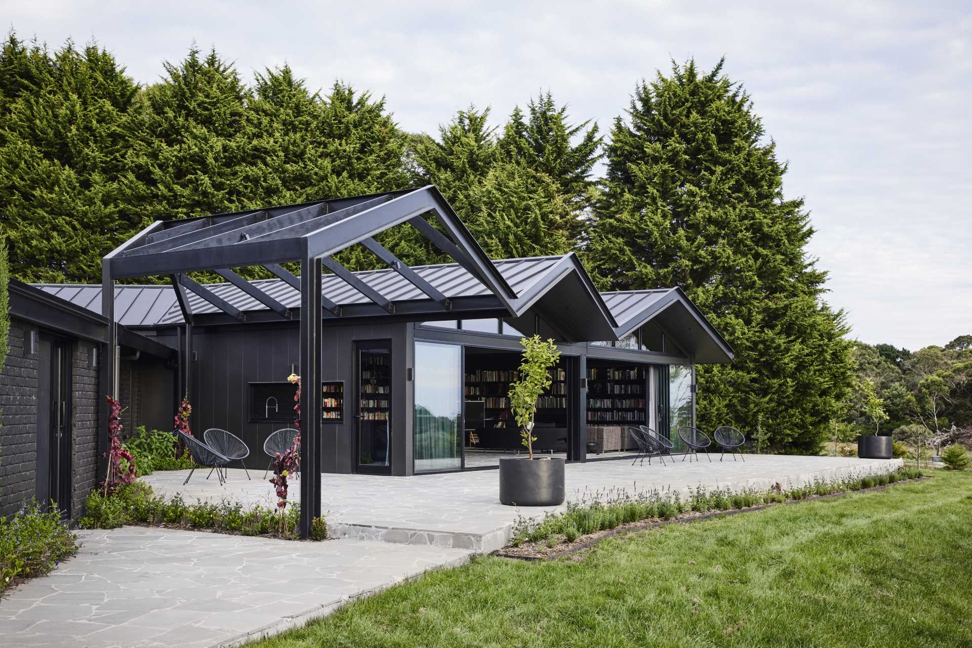 A modern farmhouse with a pitched roof and bluestone crazy paving that's featured on the terrace and the interior.