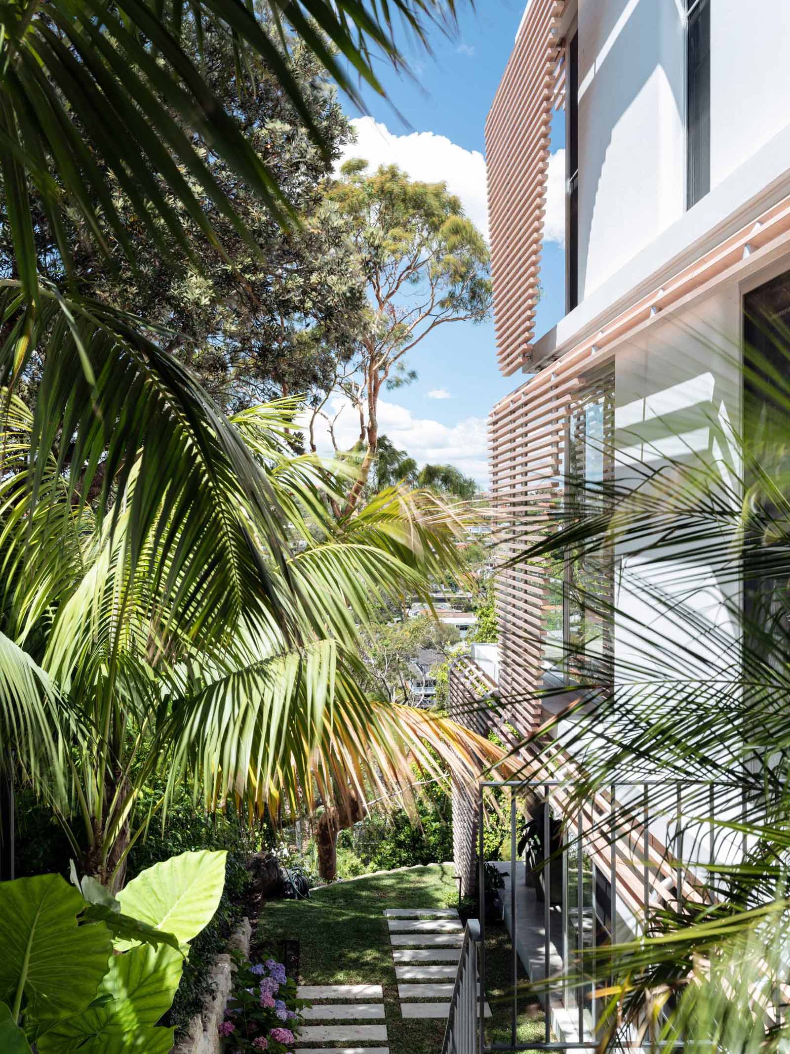The slatted screens have a subtle woodgrain that adds texture and warmth to the facade of this modern house.