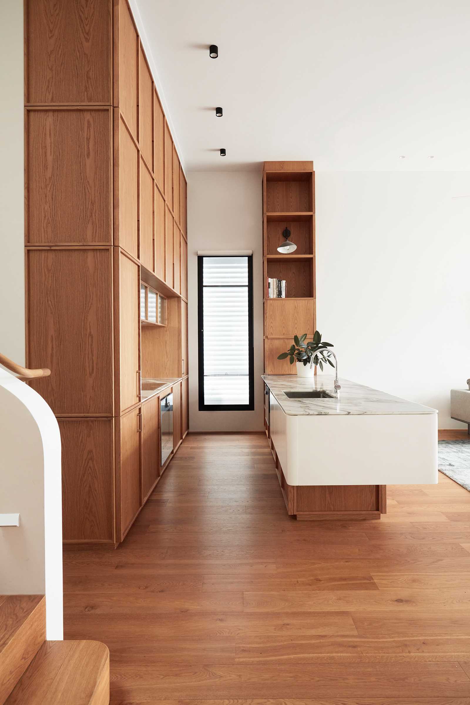 A modern kitchen with wood cabinets and stone backsplash.