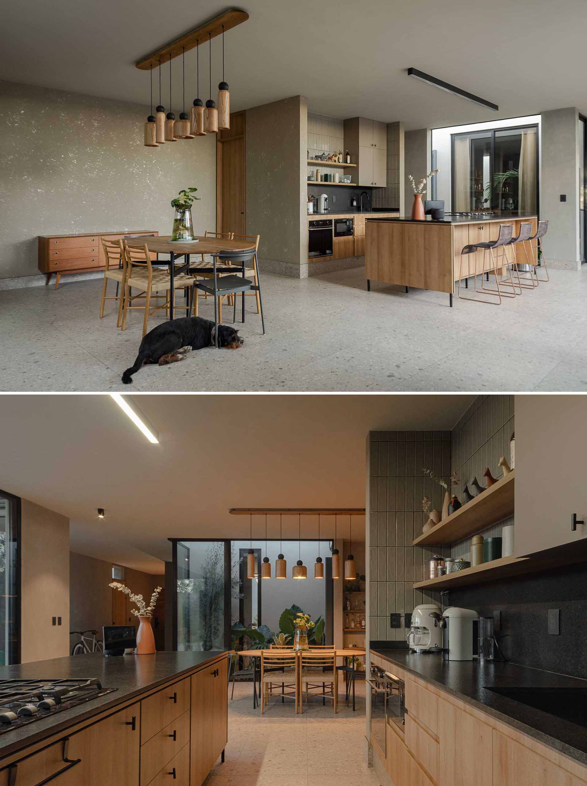 This modern and open-plan kitchen and dining area both feature wood, while the kitchen has a black backsplash that complements the window and door frames.