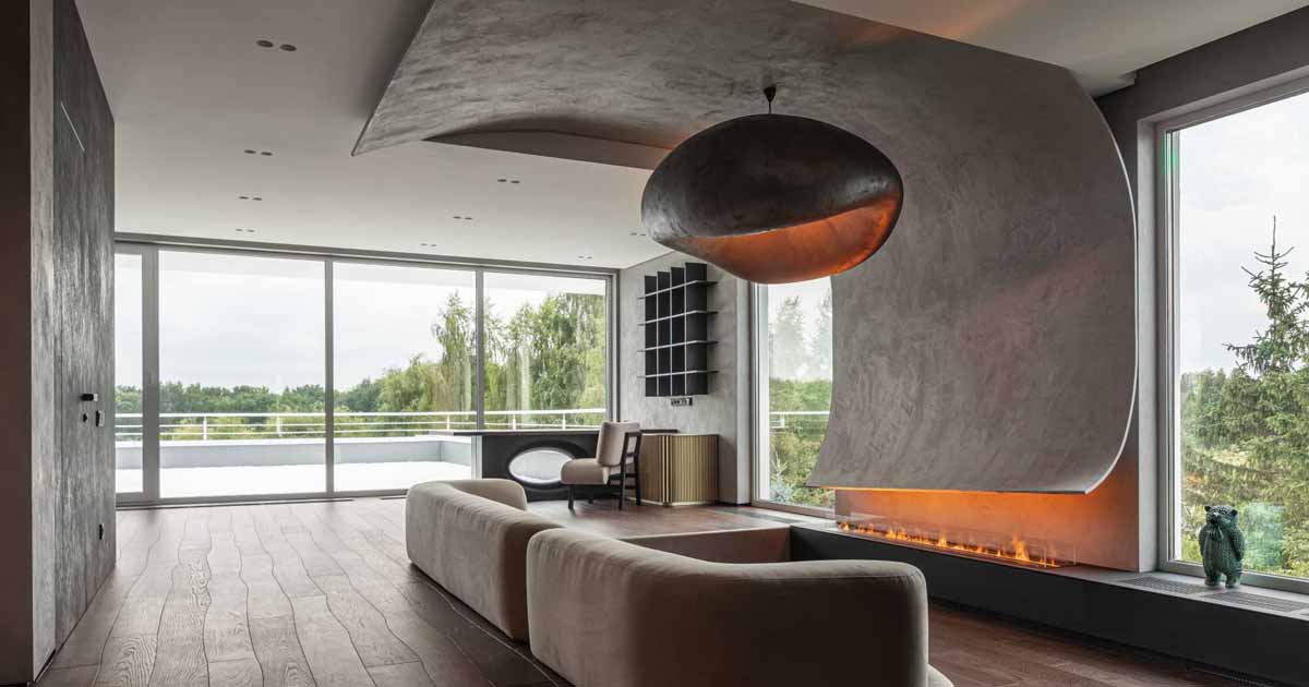 A Curved Accent Wall Wraps Around From The Fireplace To The Ceiling Inside This Home