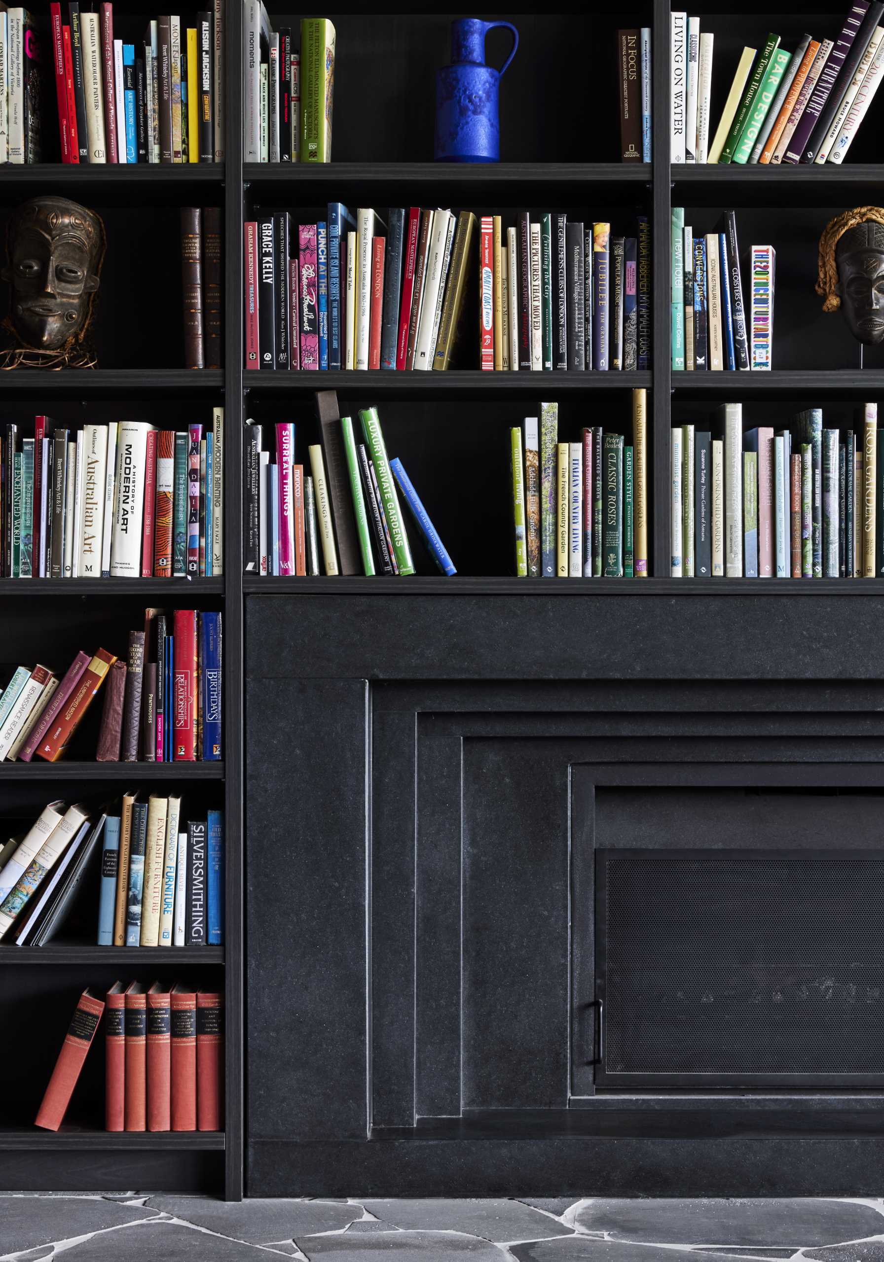 A modern living room with an abundance of bookshelves and a fireplace.