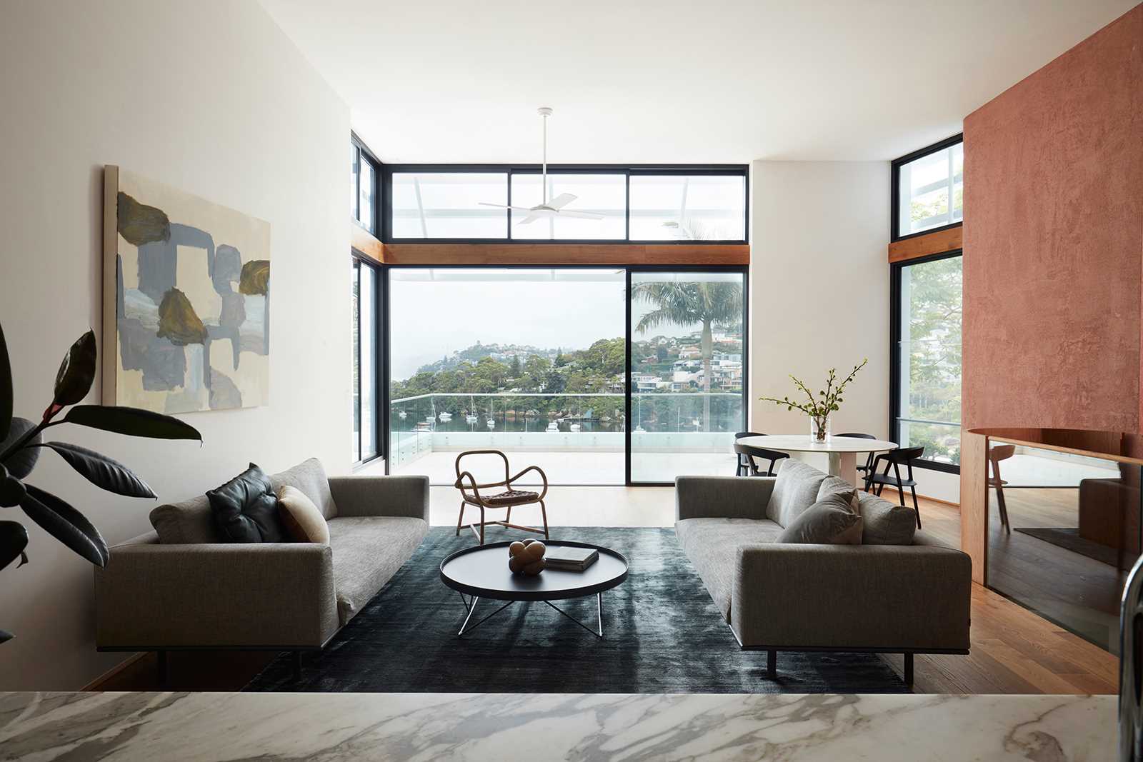 In this modern living room, there's a pair of couches, as well as a casual dining area and a fireplace.