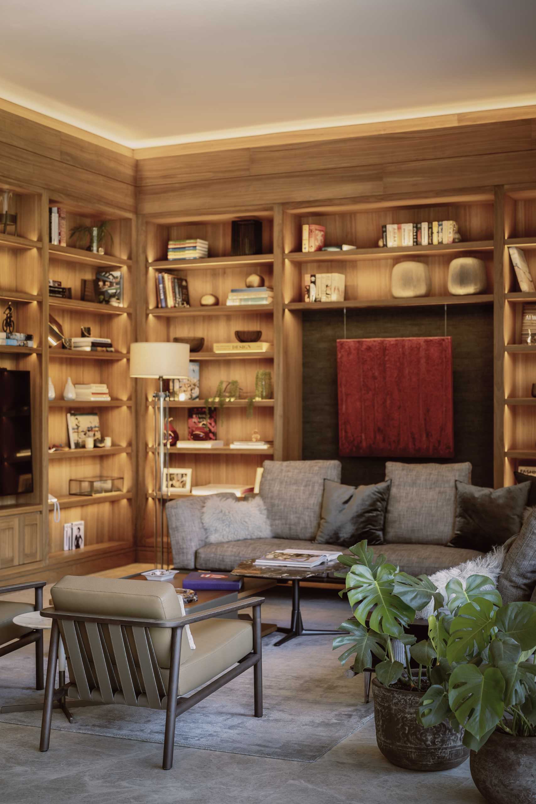 In this modern living room, embedded LED lighting lets all of the decorative elements, like books, sculptures, bowls, vases and plants, be the focus of the room. Lighting also wraps around the ceiling, casting a soft indirect glow.