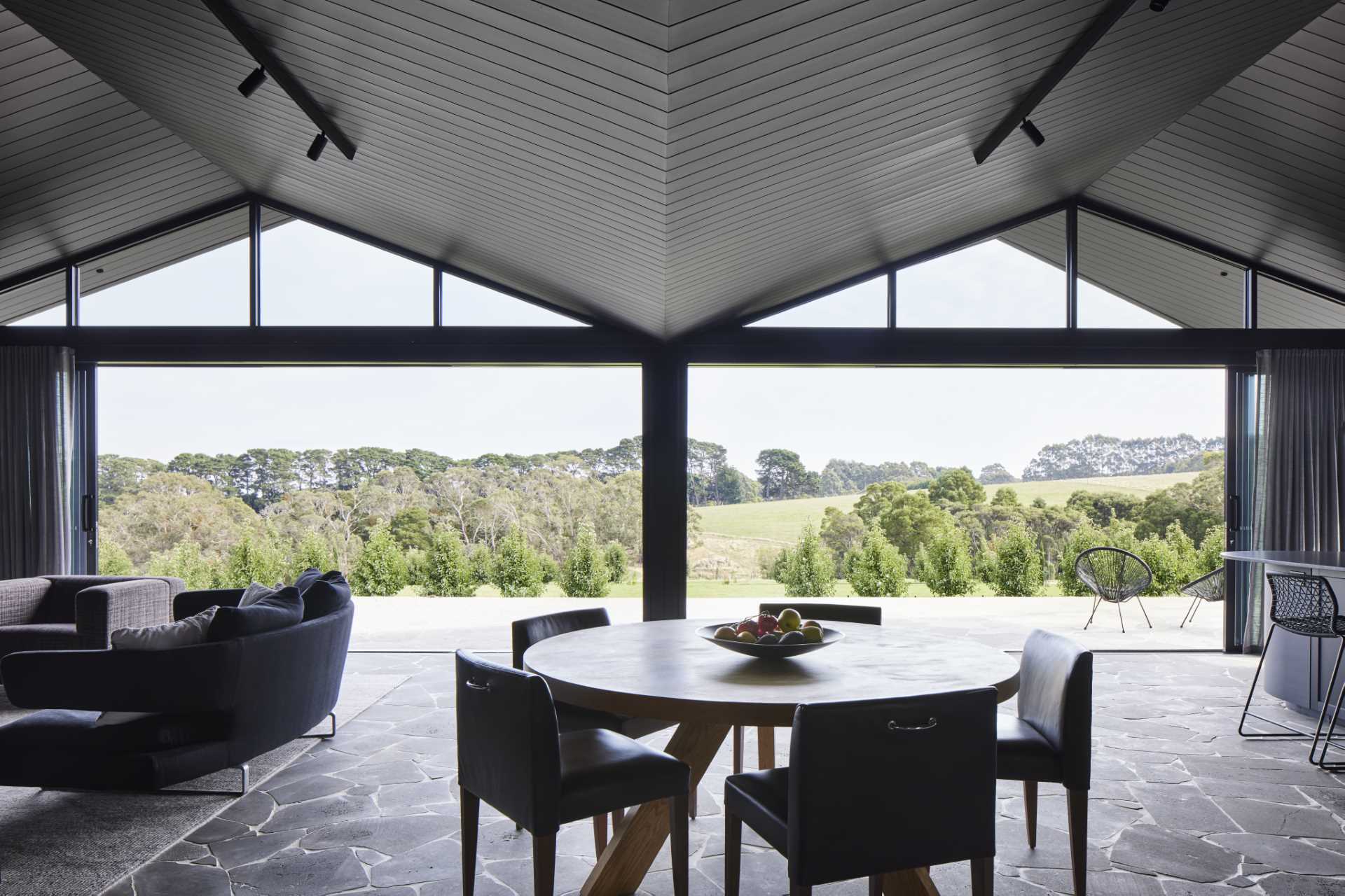 A modern farmhouse dining area with bluestone crazy paving flooring throughout.
