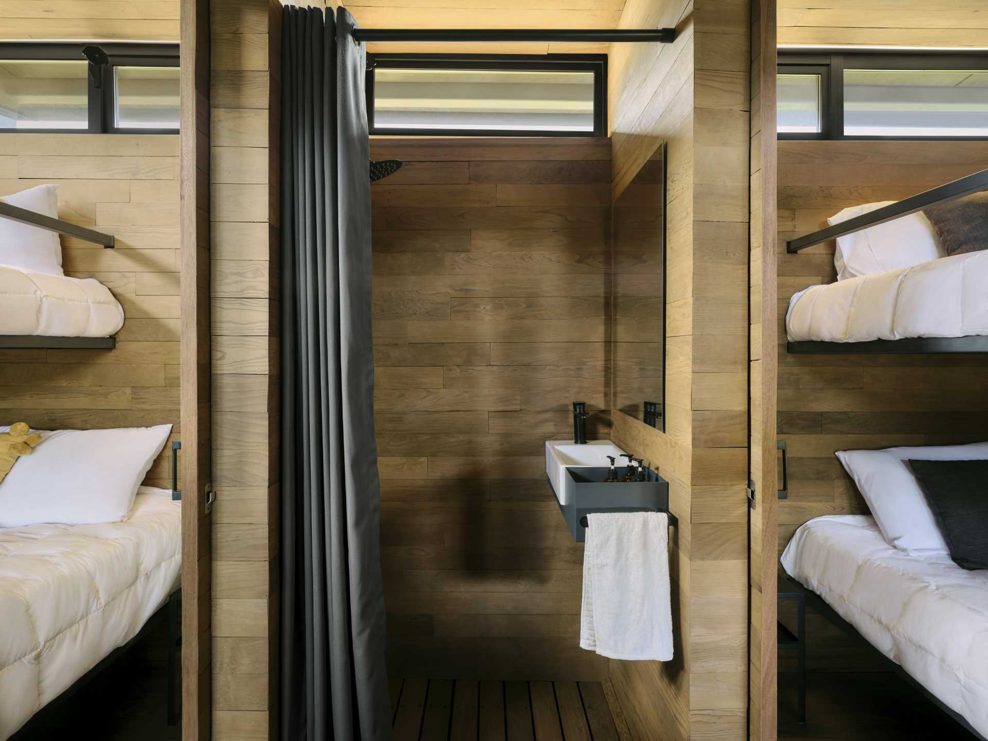 Two bedrooms with bunk beds are separated by a bathroom.