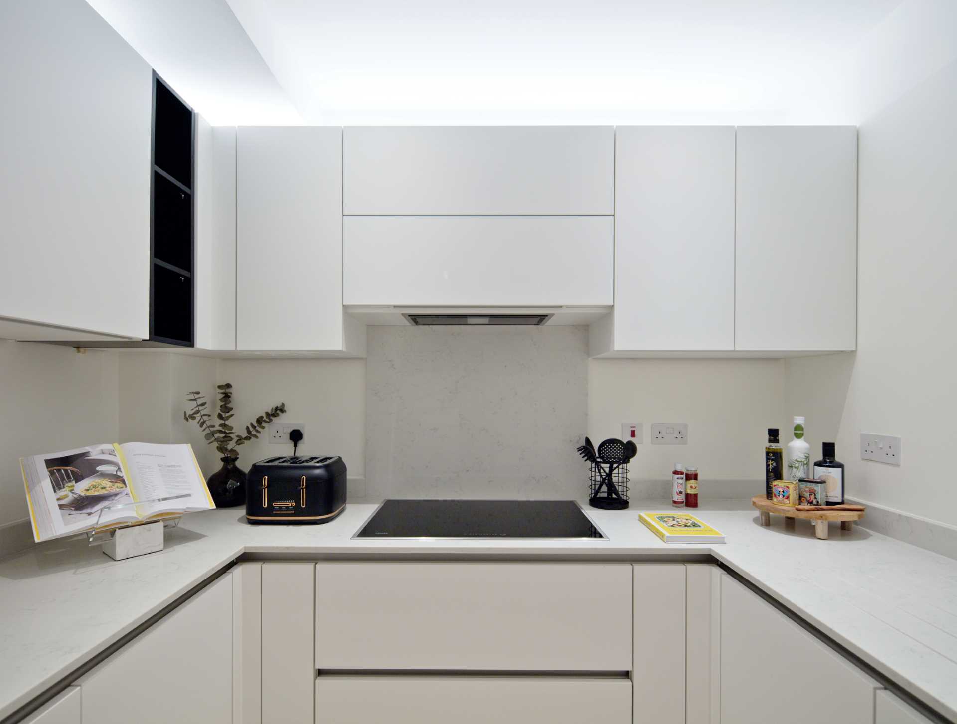 A modern white kitchen with a hardware free cabinets.