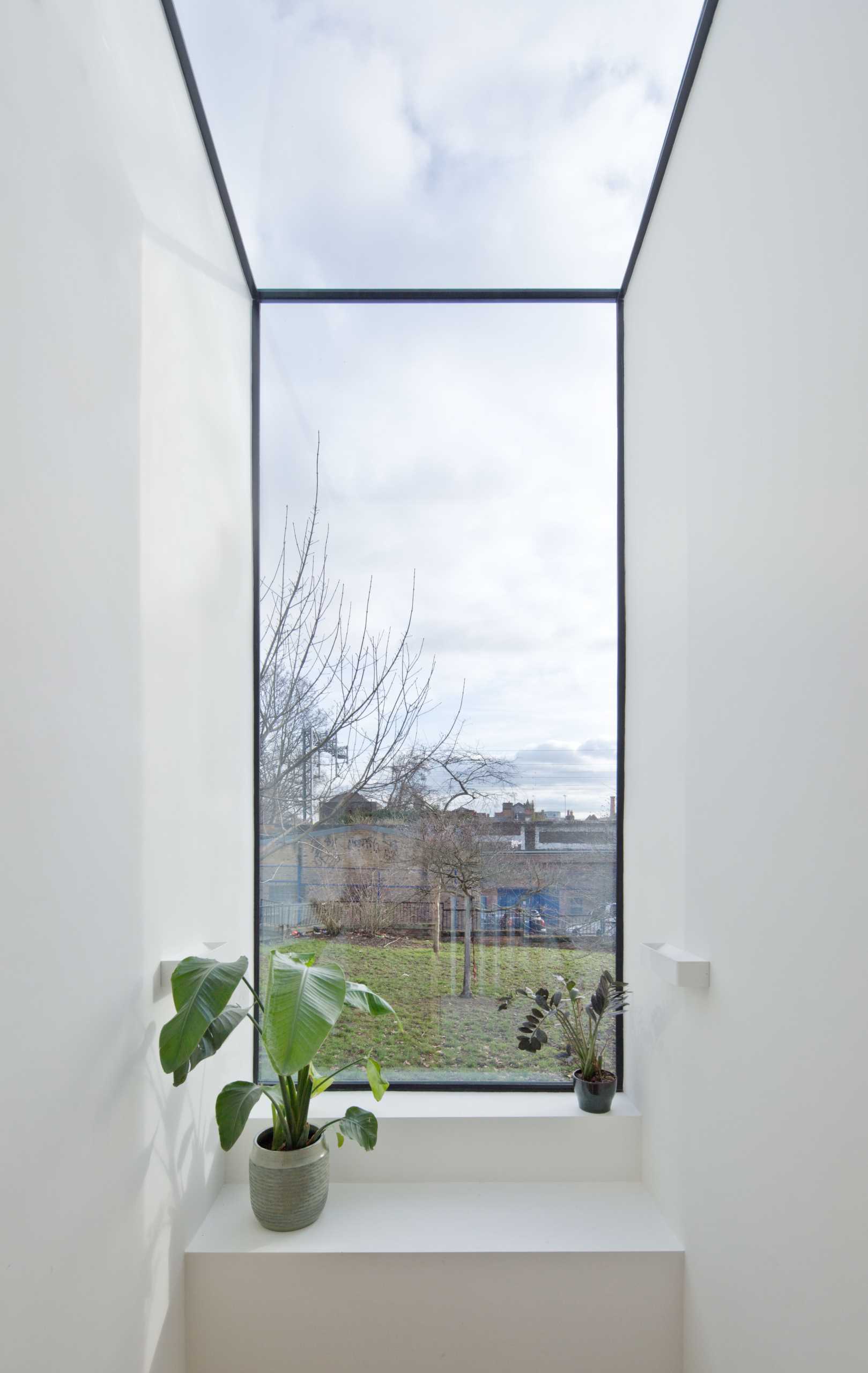 A modern window that travels from the ceiling to the wall.