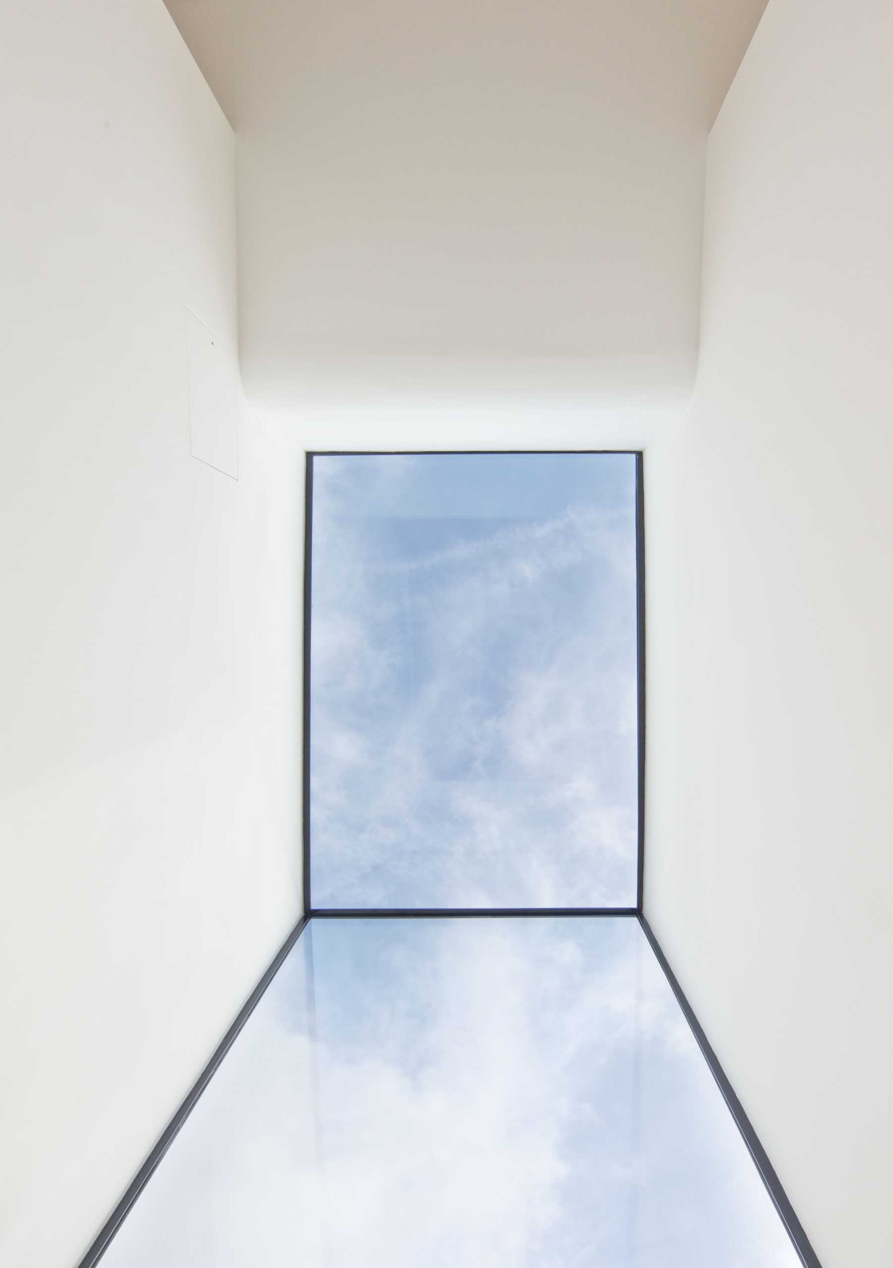 A modern window that travels from the ceiling to the wall.