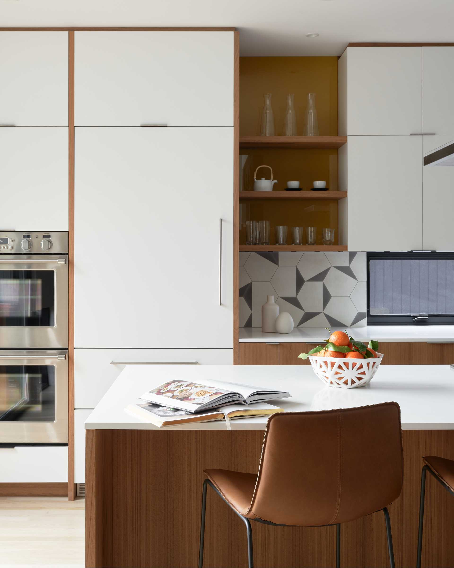 A modern white and wood kitchen with a large island.