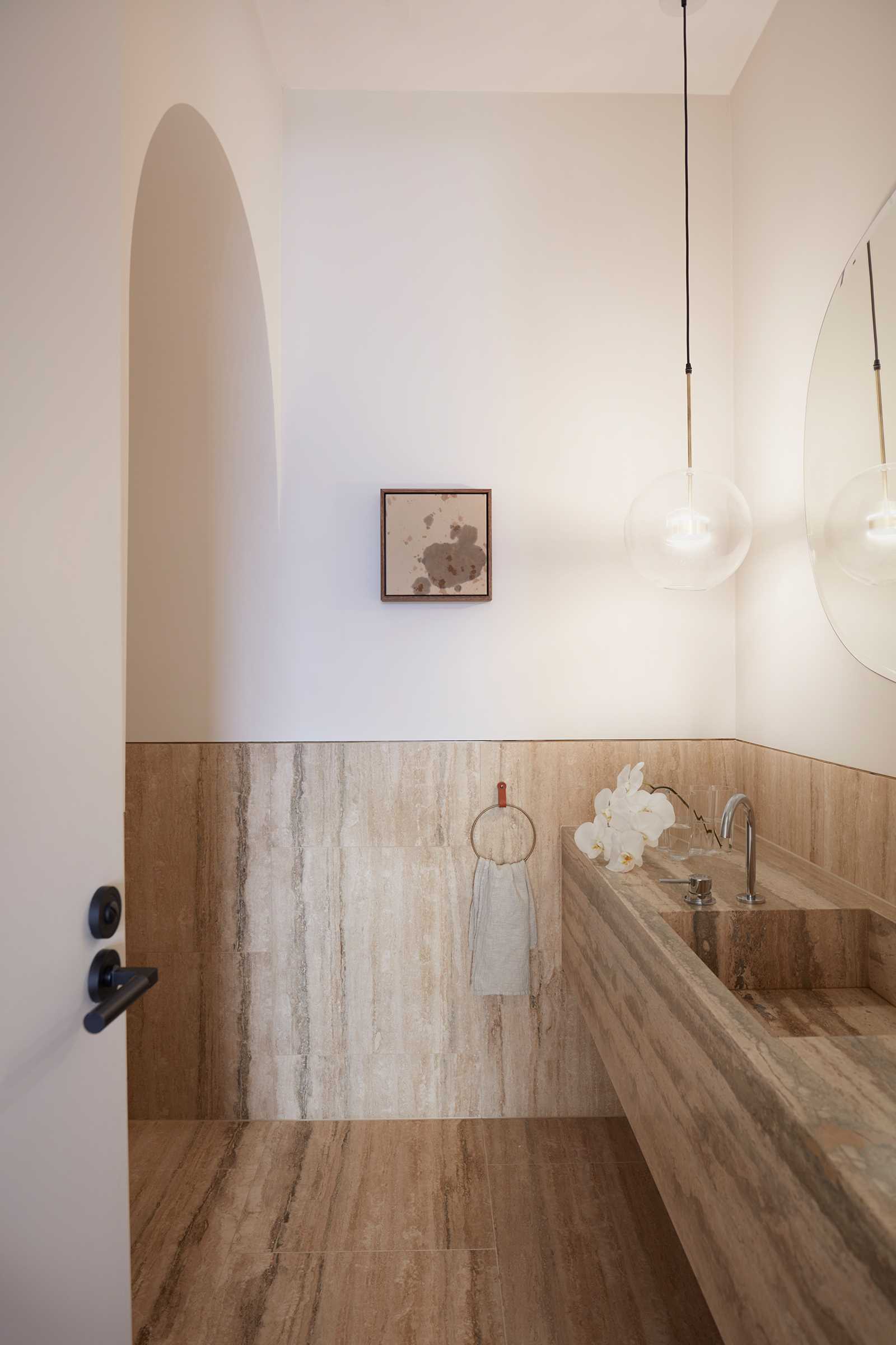 This bathroom has tiles on the wall and floor that match the vanity.