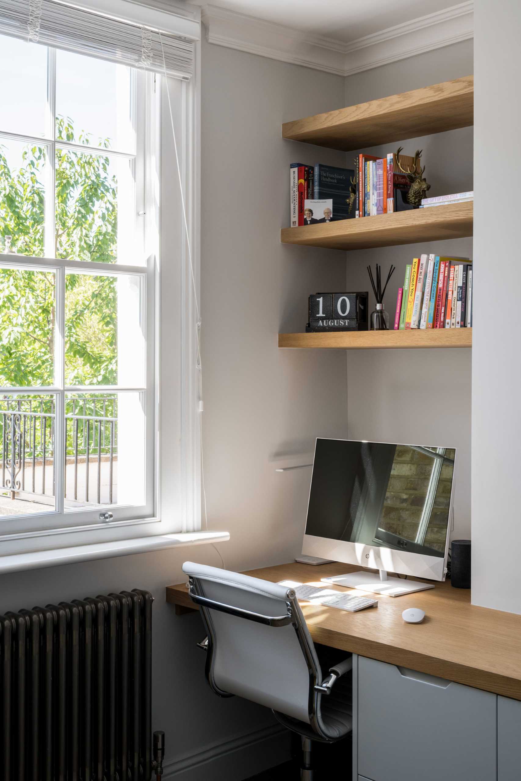 A bedroom niche was filled with built-in shelves and a desk to create a small work area.
