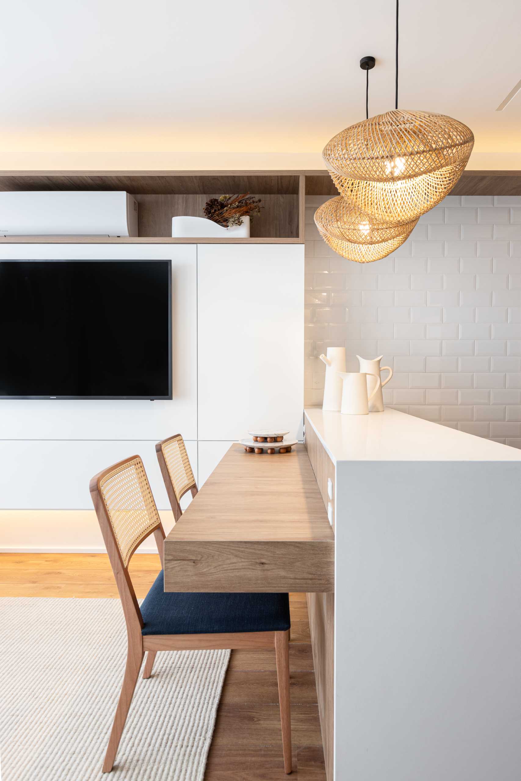 This small kitchen has a peninsula with a counter for seating, which also acts as a dining area or a desk.