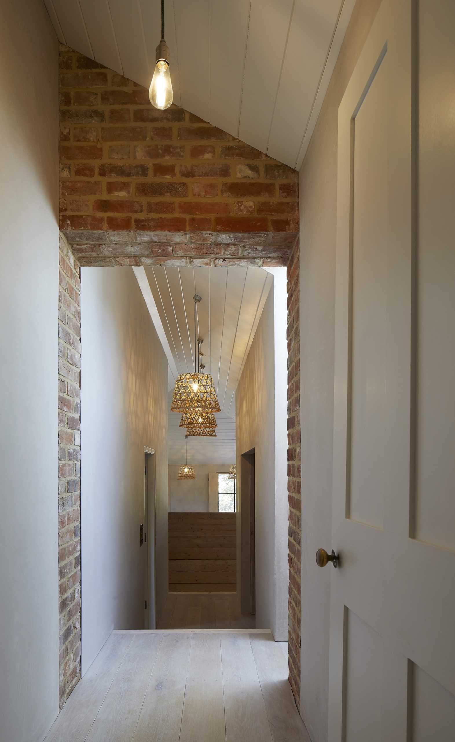 An old brick house with a new extension shows of the original brick walls and windows.