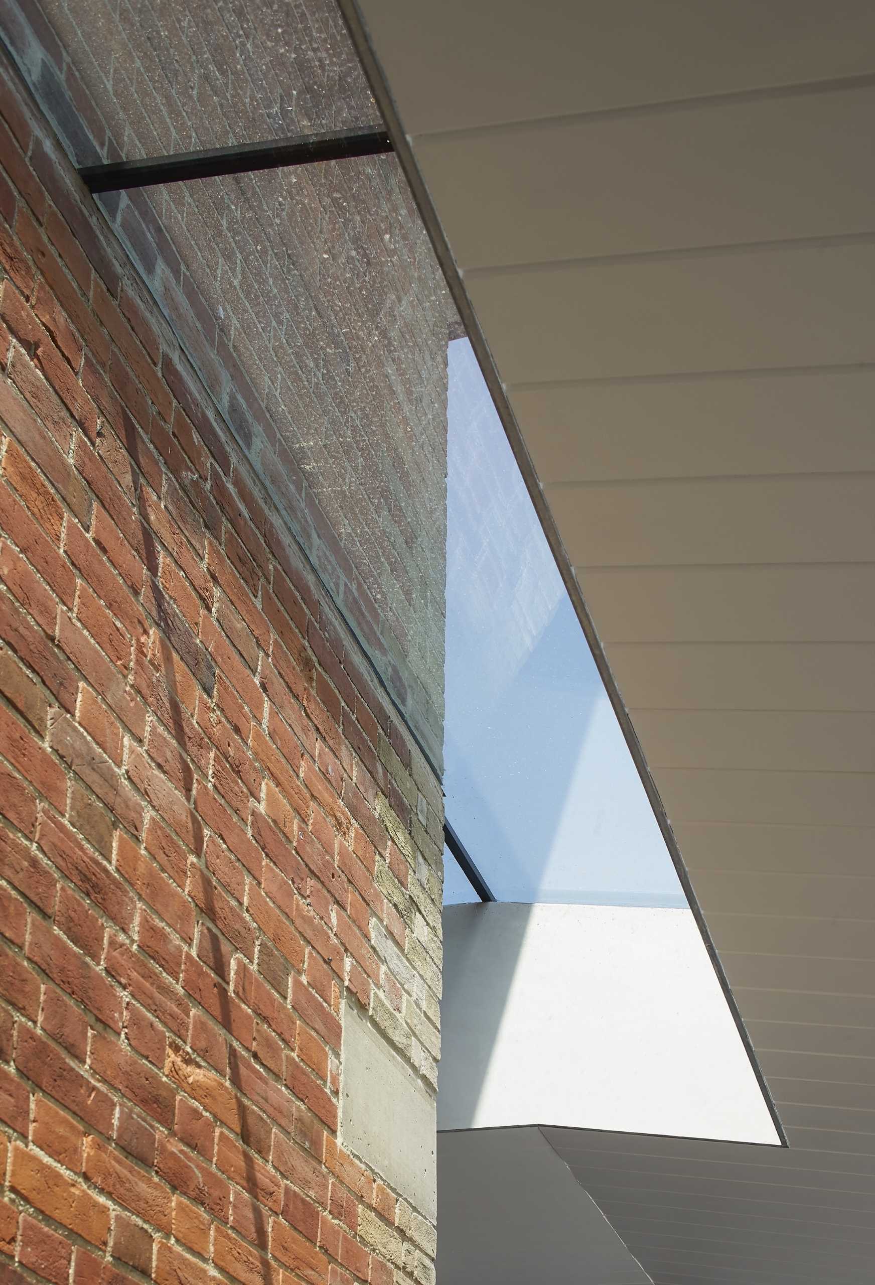 An old brick house with a new extension shows of the original brick walls and windows.