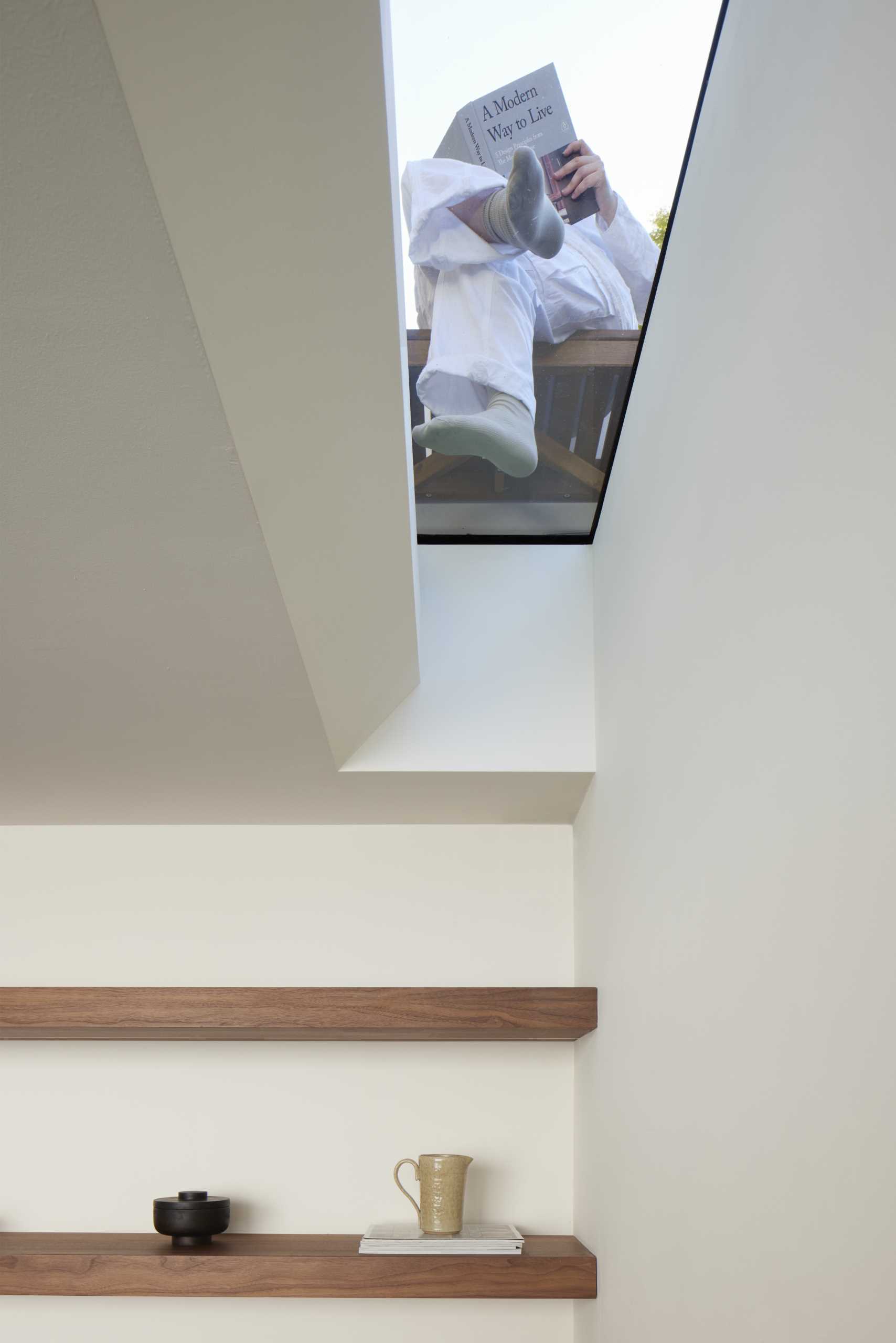 A ceiling window in a breakfast room allows natural light to filter through to the room, as well as provide a view of the patio above.