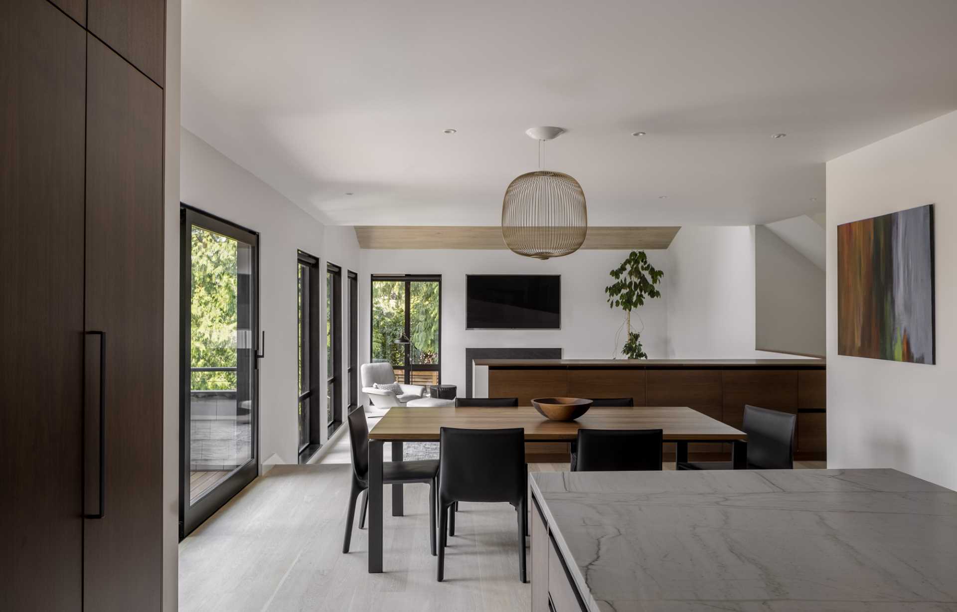 The dining room opens up to an outdoor space with a lounge area and provides a separation between the living room and kitchen.