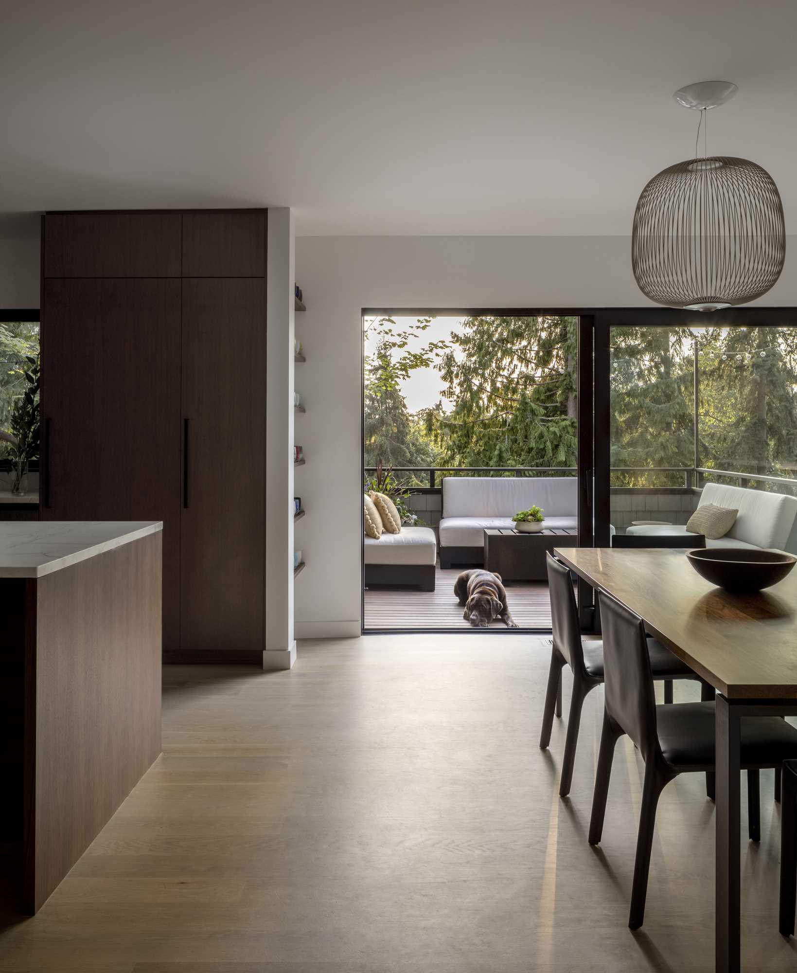 The dining room opens up to an outdoor space with a lounge area and provides a separation between the living room and kitchen.